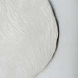 Assiette sur pied en grès D23,5cm- Blanc texturé gravé de Claire Cosnefroy chez Brutal Ceramics