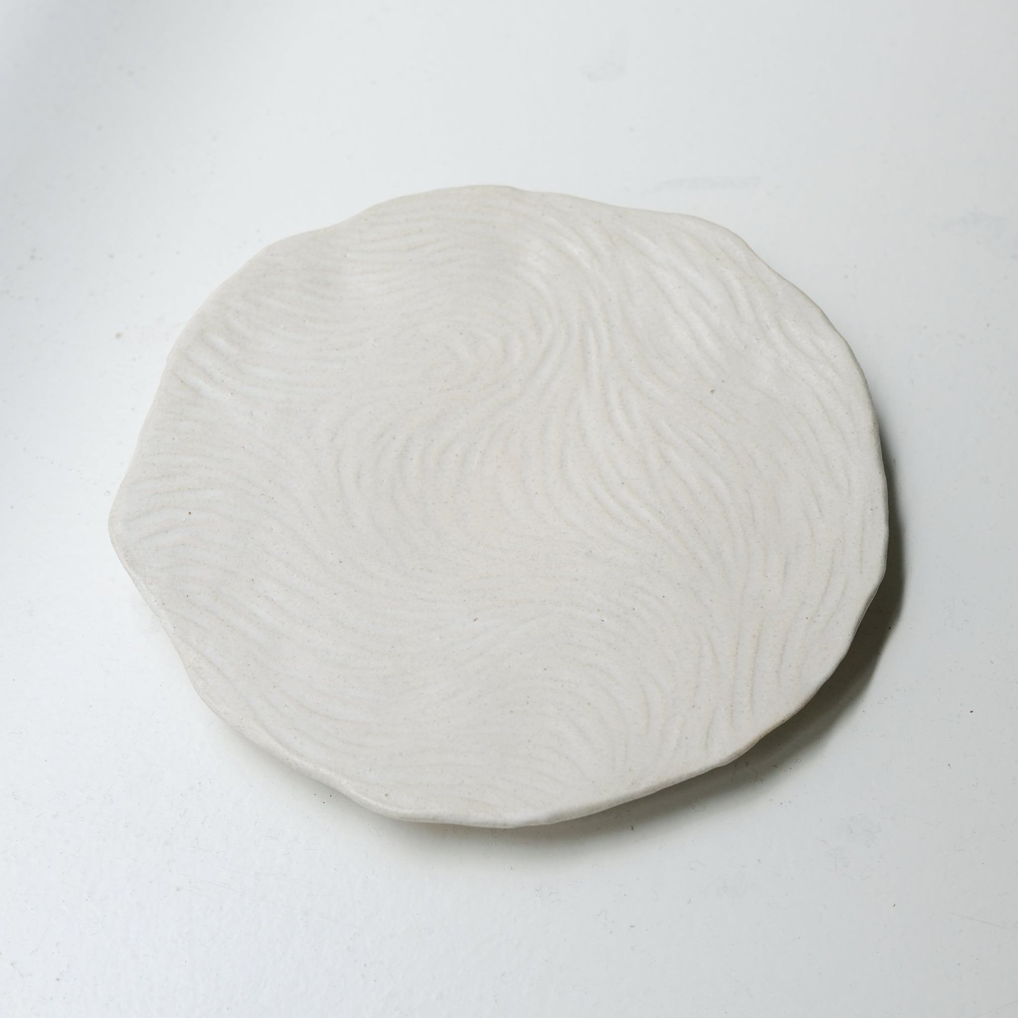 Assiette sur pied en grès D23,5cm- Blanc texturé gravé de Claire Cosnefroy chez Brutal Ceramics