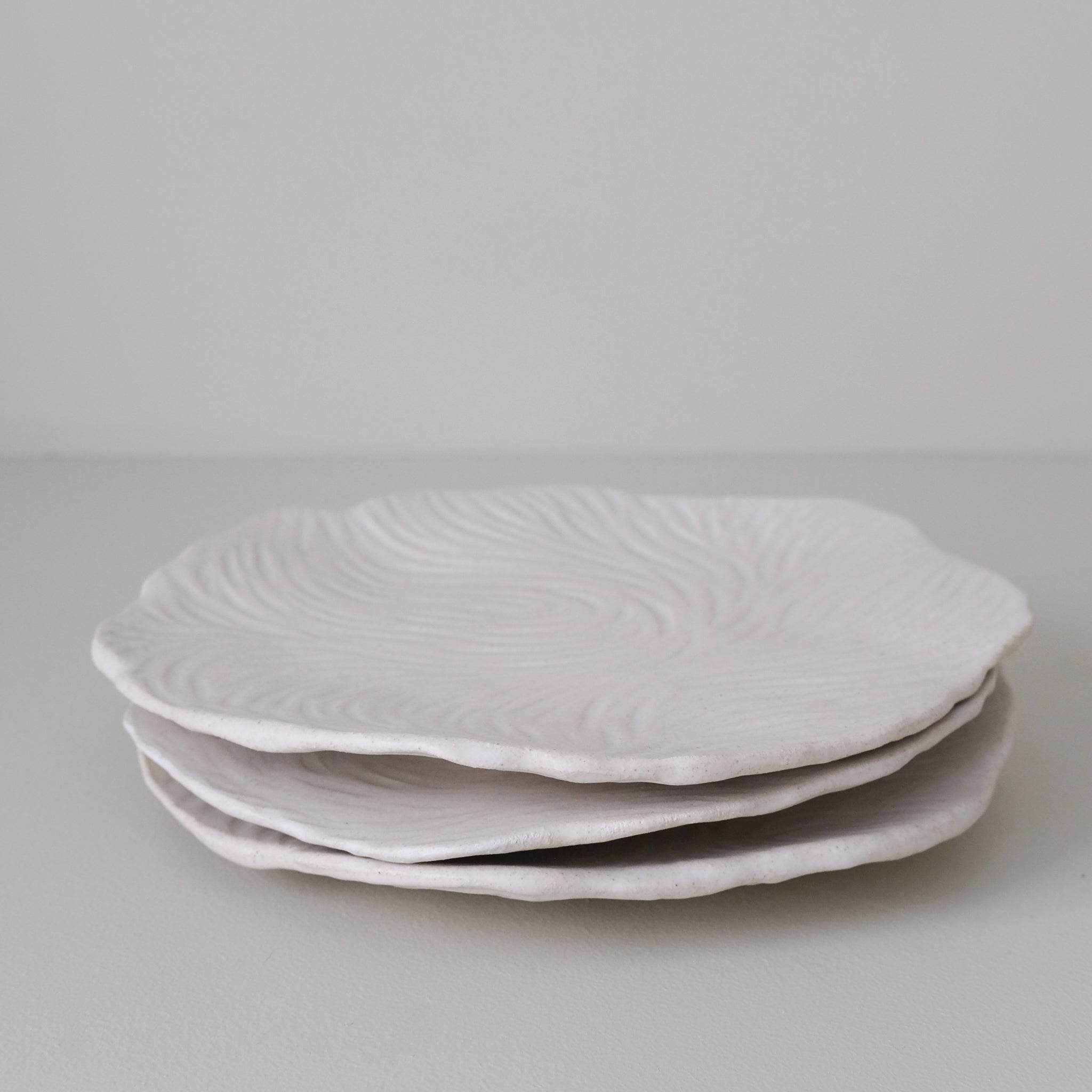 Assiette sur pied en grès D23,5cm- Blanc texturé gravé de Claire Cosnefroy chez Brutal Ceramics