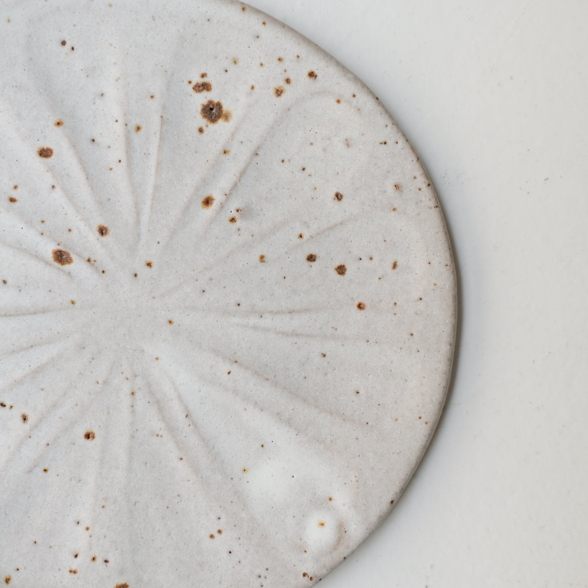 Assiette "Fleurs" en grès D 18cm - blanc tacheté d'Hélène Maury chez Brutal Ceramics