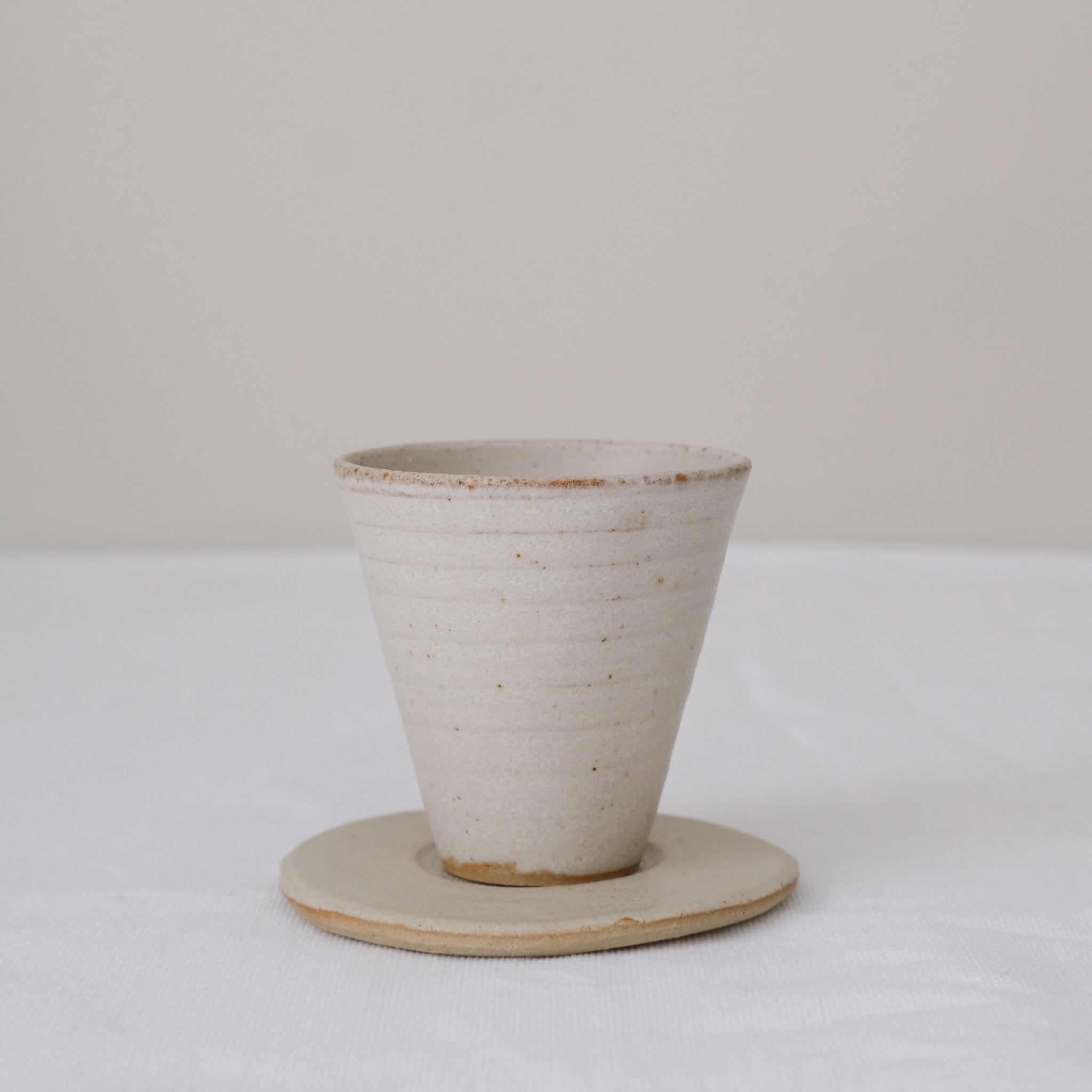 Set soucoupe et tasse en grès blanc 60ml - blanc beige de Louise Traon chez Brutal Ceramics