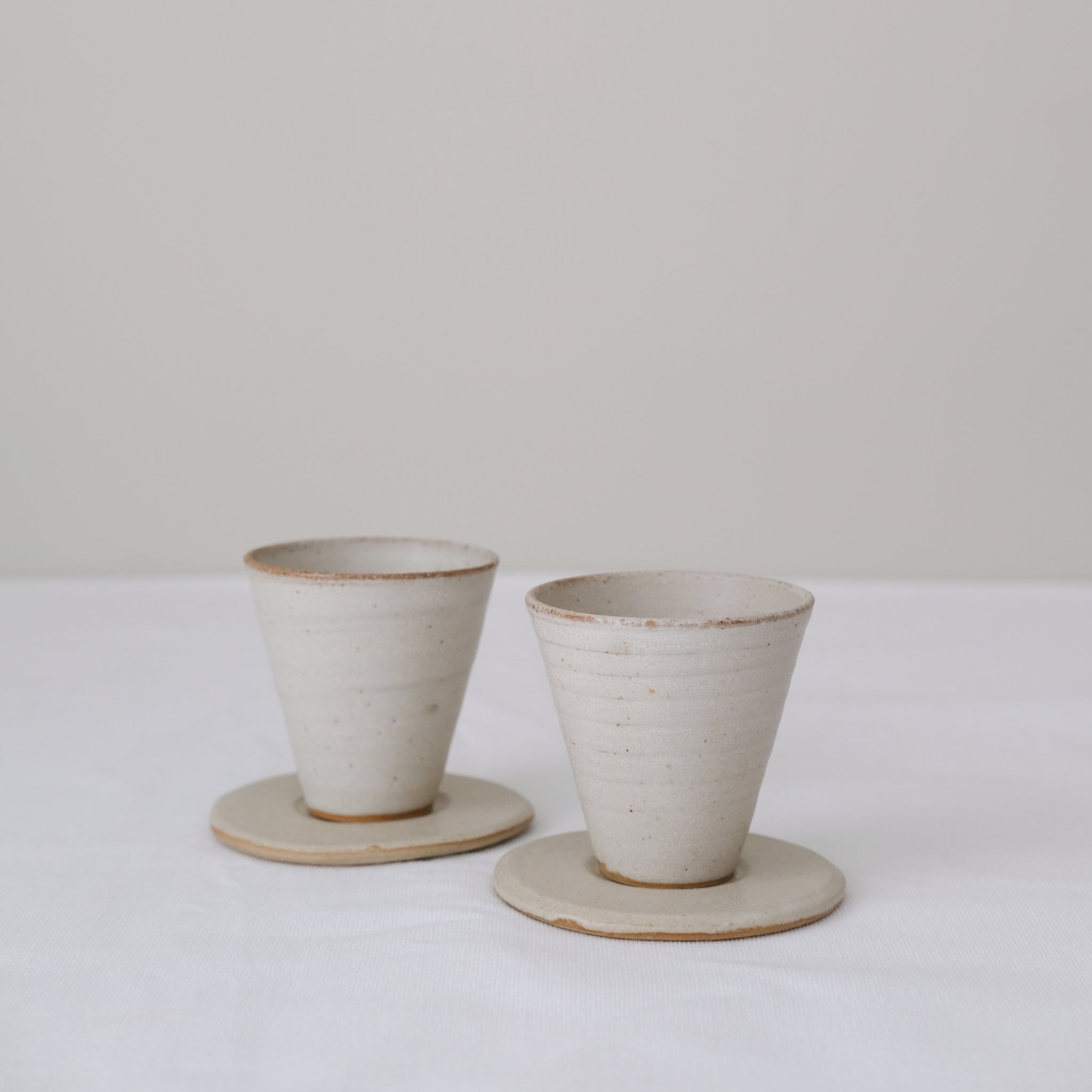 Set soucoupe et tasse en grès blanc 60ml - blanc beige de Louise Traon chez Brutal Ceramics