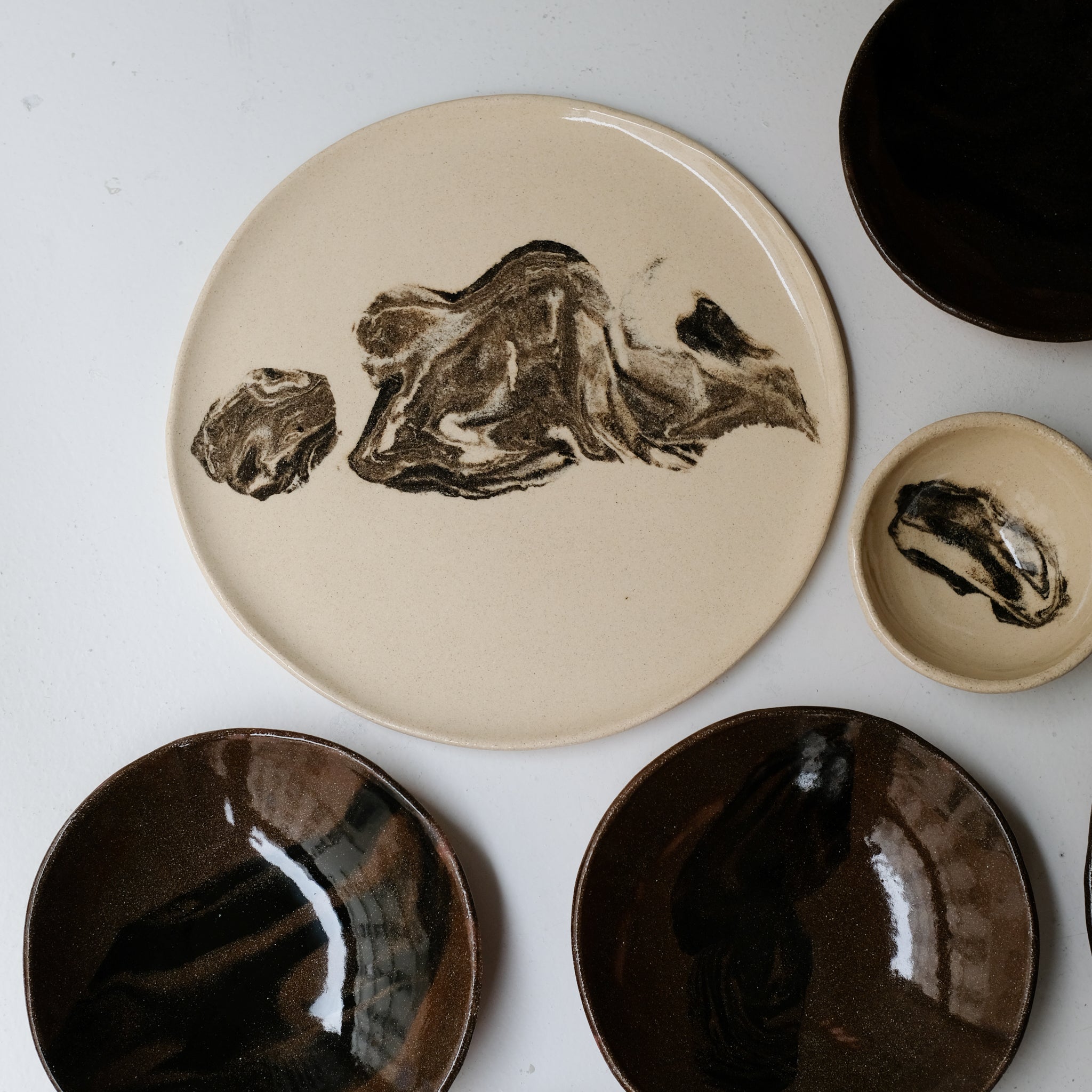 Plat rond D 32cm en terres mêlées - noir et beige de Léa Baldassari chez Brutal Ceramics
