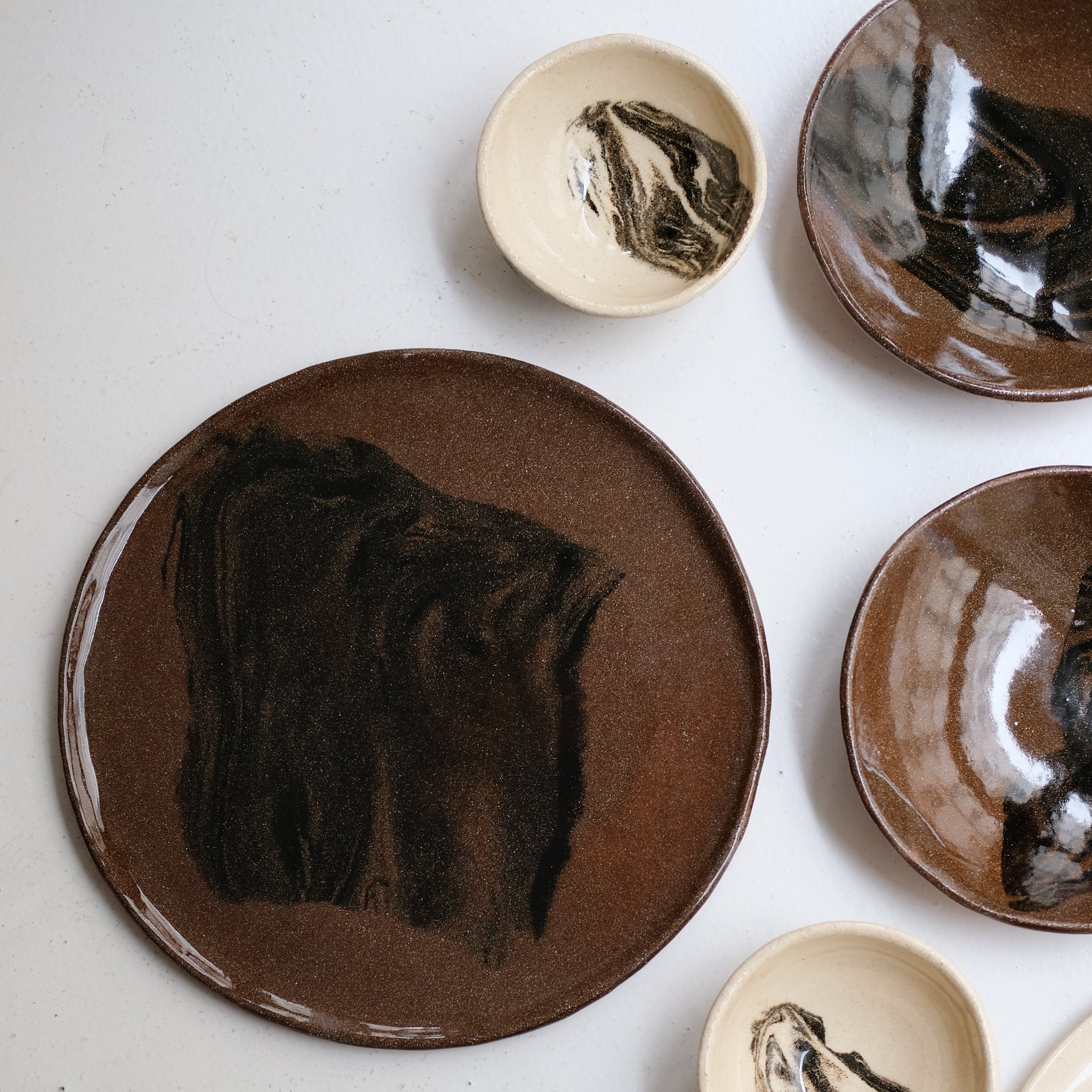 Plat rond D 32cm en terres mêlées - noir et brun de Léa Baldassari chez Brutal Ceramics