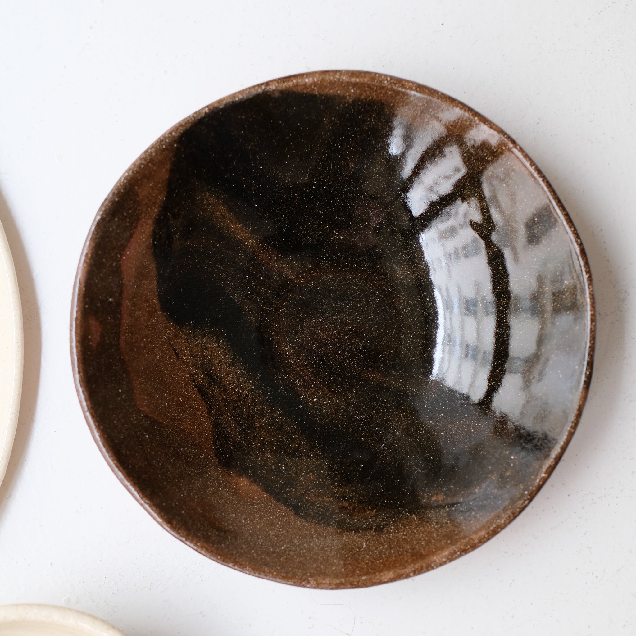 Assiette creuse D 21cm en terres mêlées - noir et brun de Léa Baldassari chez Brutal Ceramics