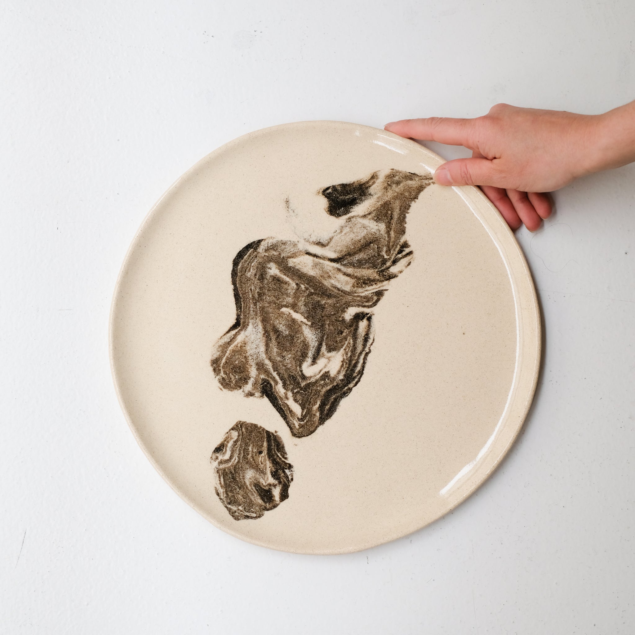 Plat rond D 32cm en terres mêlées - noir et beige de Léa Baldassari chez Brutal Ceramics