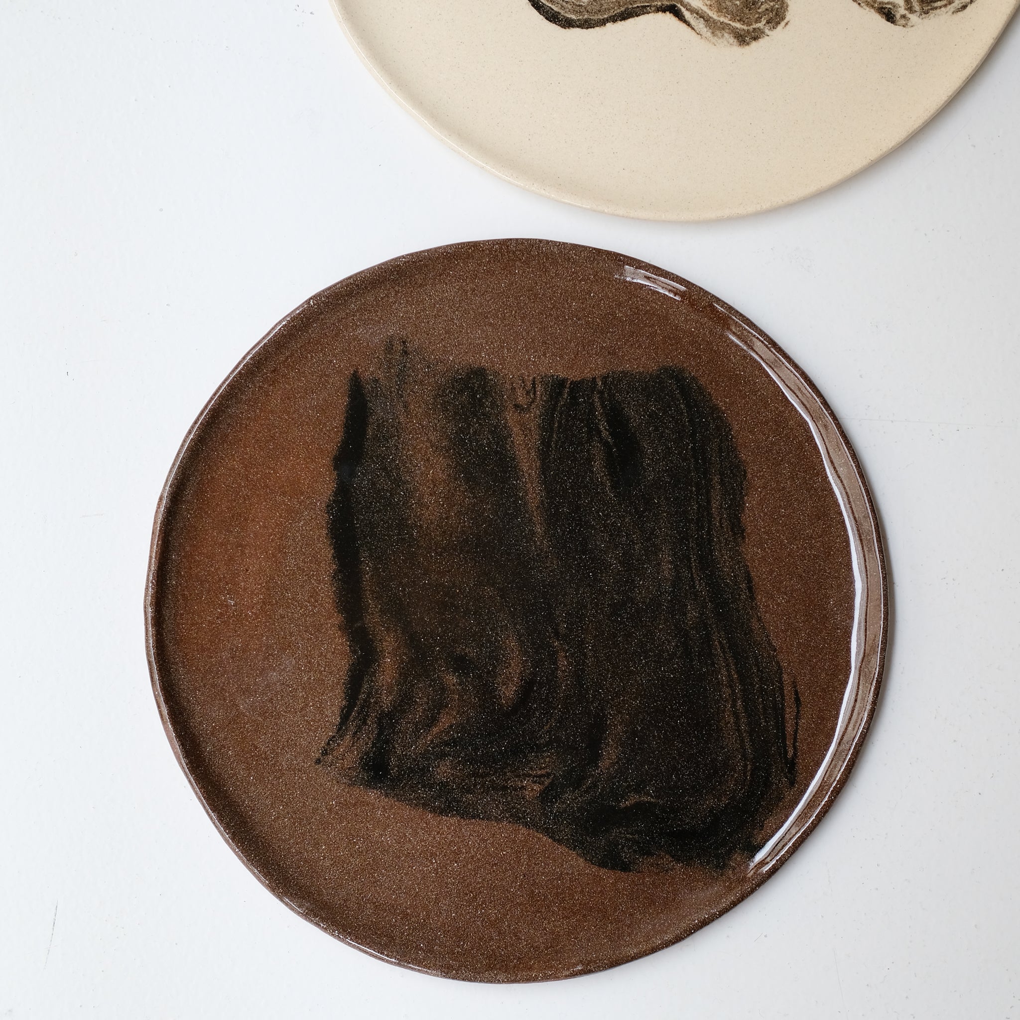 Plat rond D 32cm en terres mêlées - noir et brun de Léa Baldassari chez Brutal Ceramics