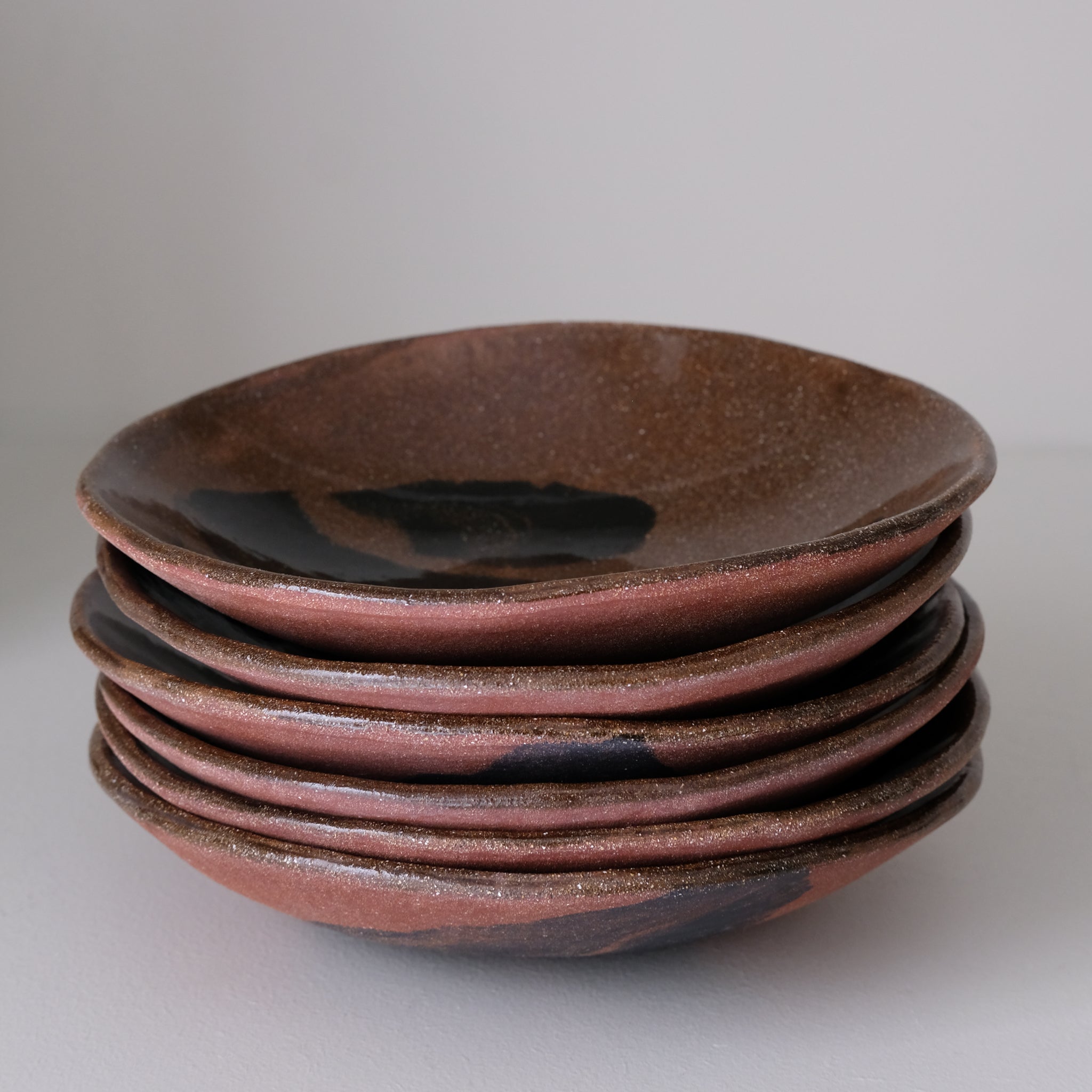 Assiette creuse D 21cm en terres mêlées - noir et brun de Léa Baldassari chez Brutal Ceramics