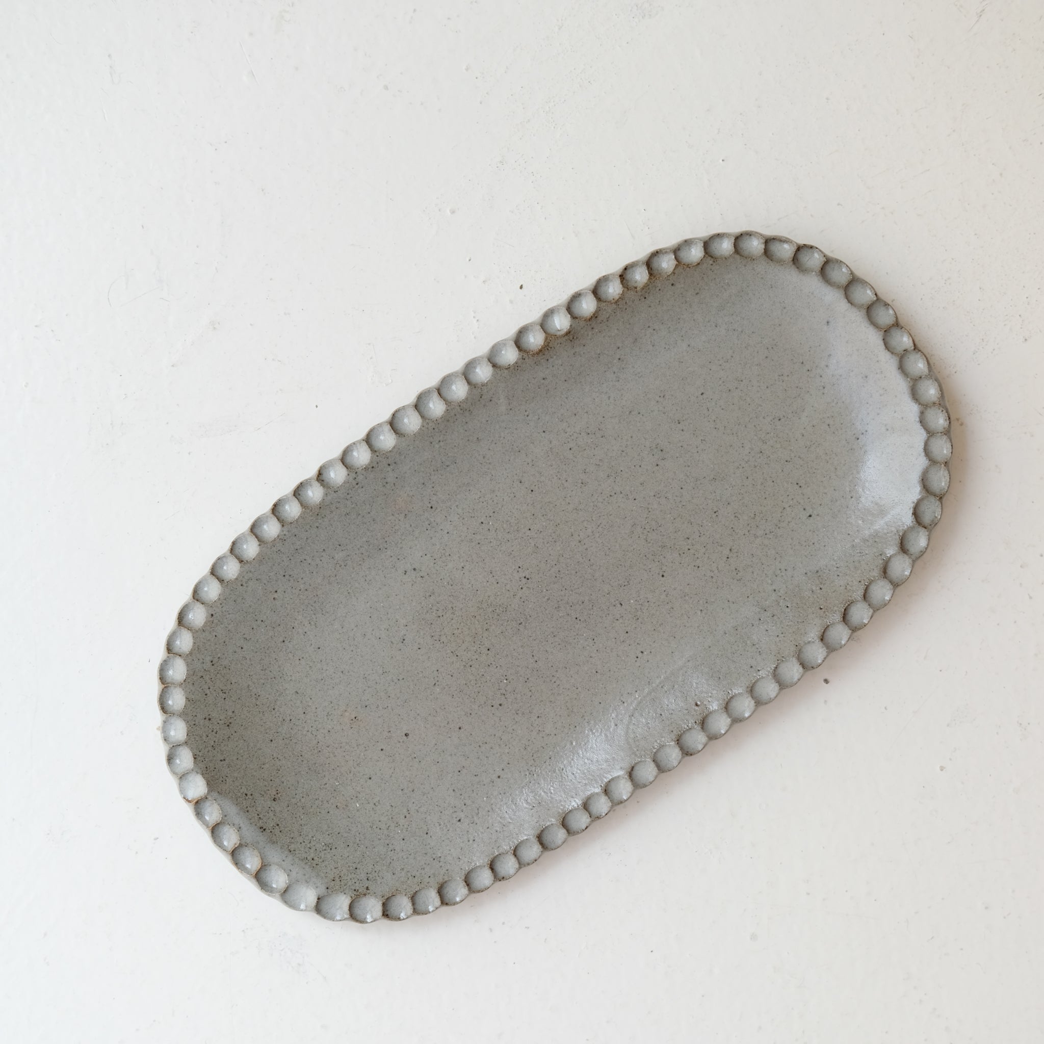 Plat oval cranté en grès L 23cm - gris bleu de Lisa Streich chez Brutal Ceramics