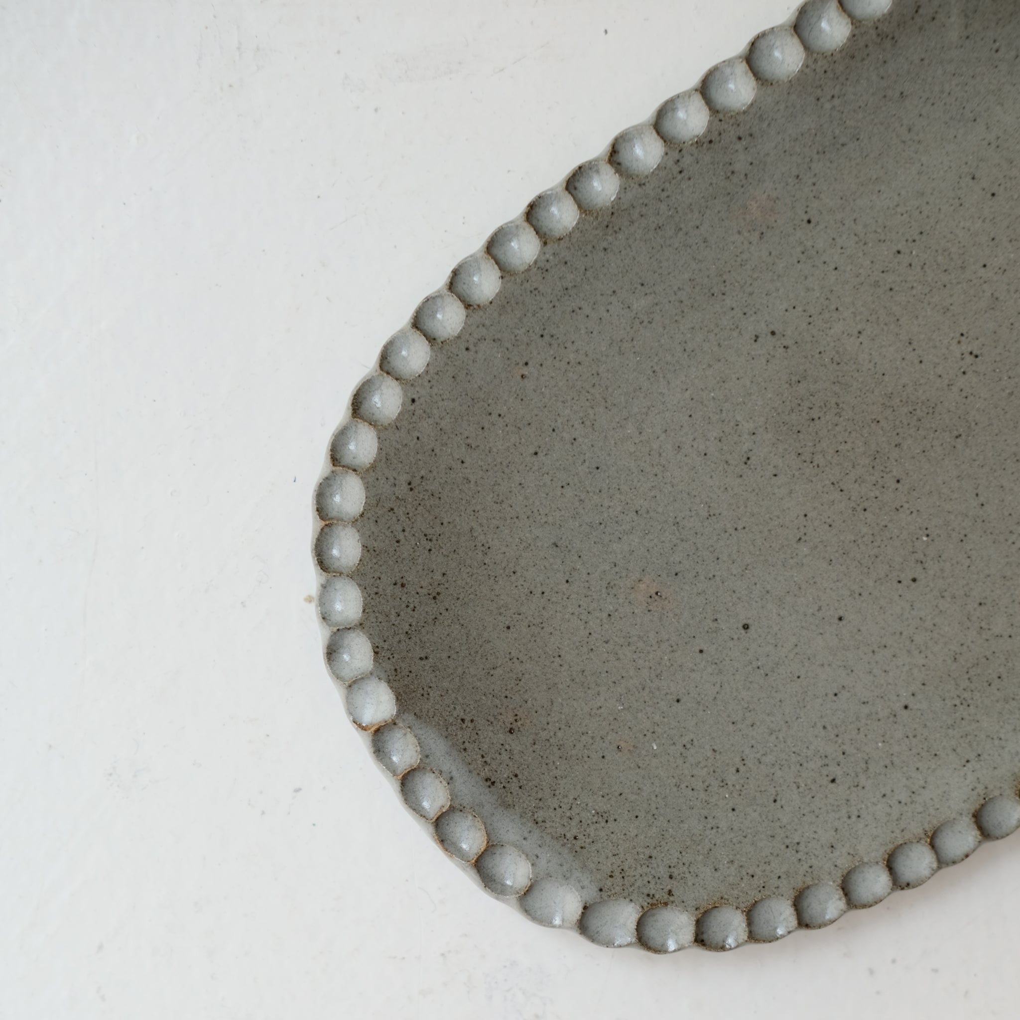 Plat oval cranté en grès L 23cm - gris bleu de Lisa Streich chez Brutal Ceramics