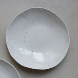 Assiette en porcelaine blanc moucheté bleu par la céramiste Elsa Haas