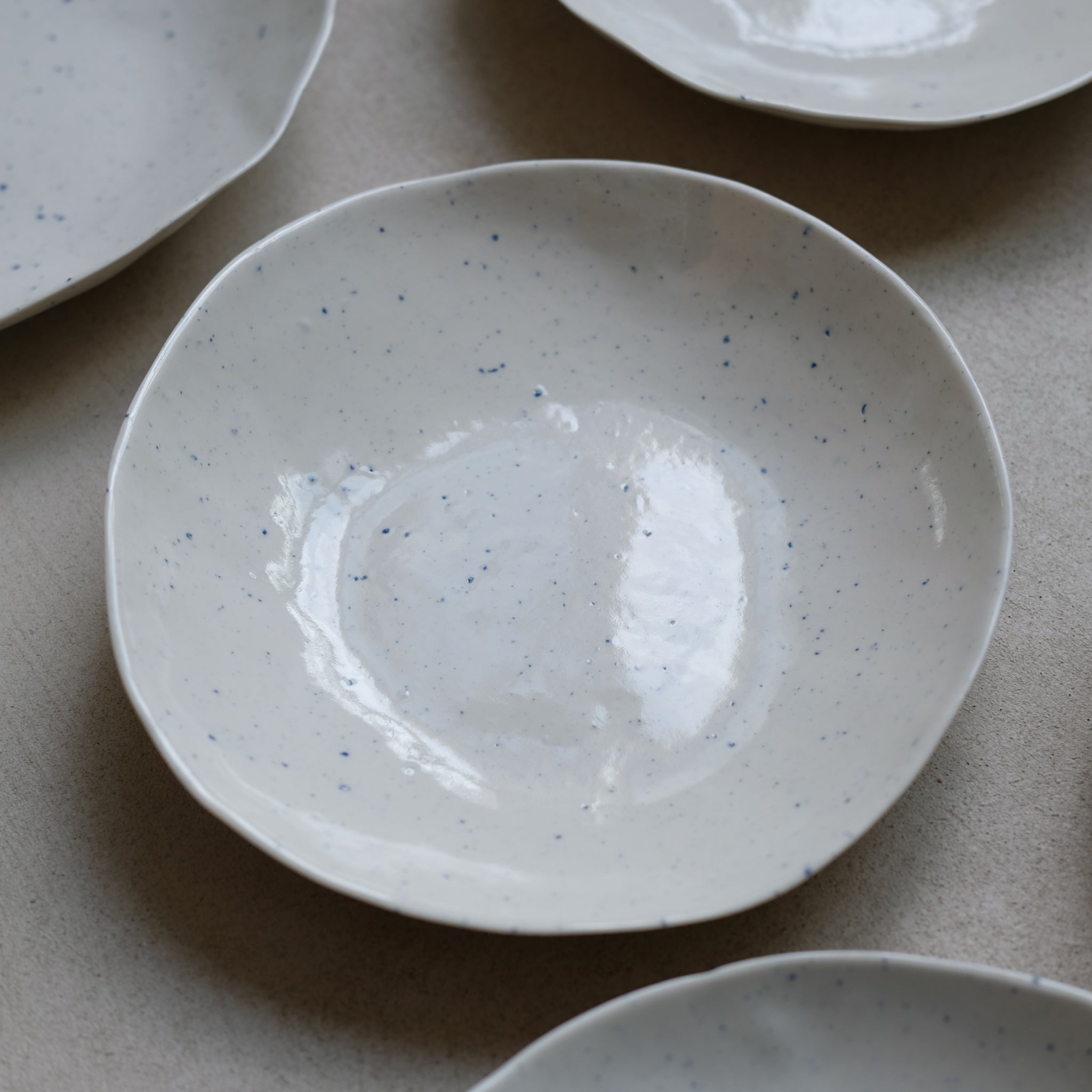 Assiette en porcelaine blanc moucheté bleu par la céramiste Elsa Haas