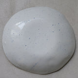 Assiette en porcelaine blanc moucheté bleu par la céramiste Elsa Haas