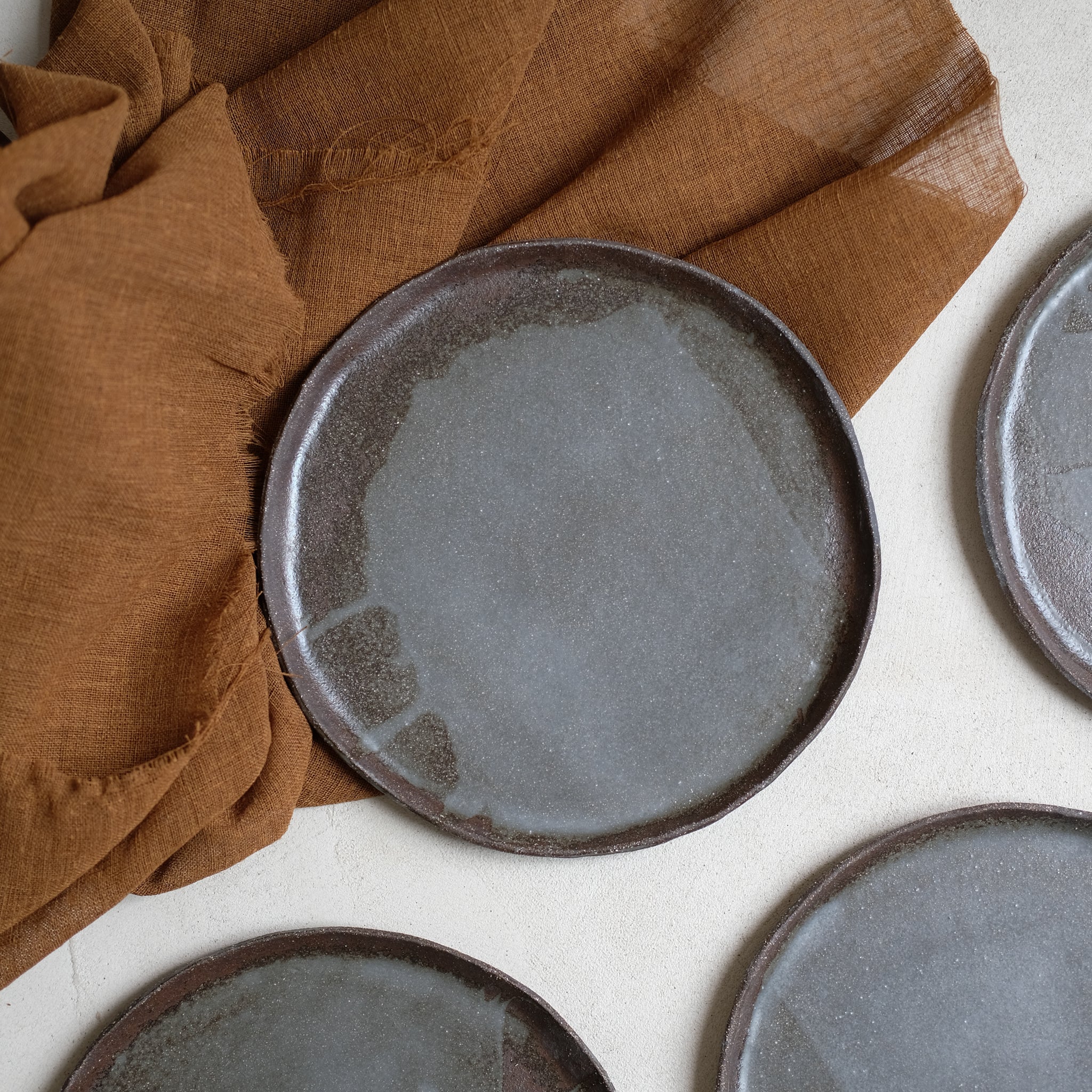 Assiette en grès noir chamotté de la céramiste Elsa Haas