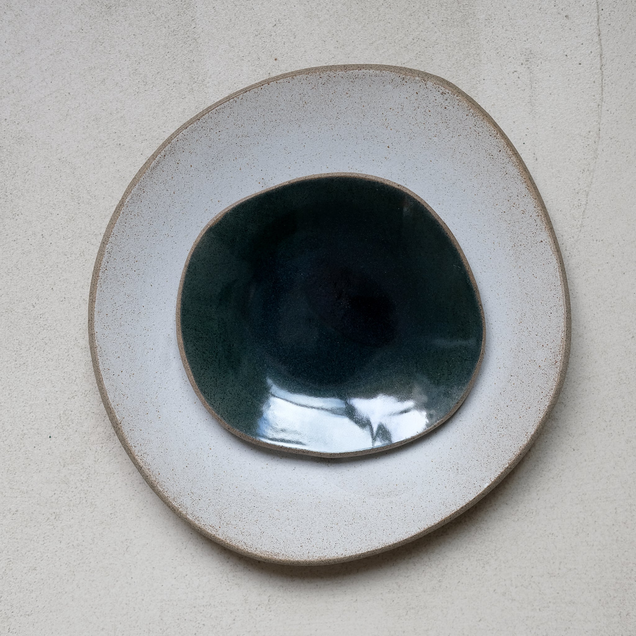 Assiette blanche en grès gris L 25cm par Hana Karim chez Brutal Ceramics