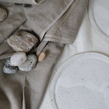 Grande assiette en grès blanc moucheté par Lucie Faucon chez Brutal Ceramics