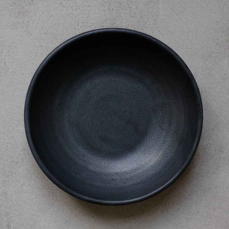 Assiette creuse en argile gris de Perla Valtierra chez Brutal Ceramics