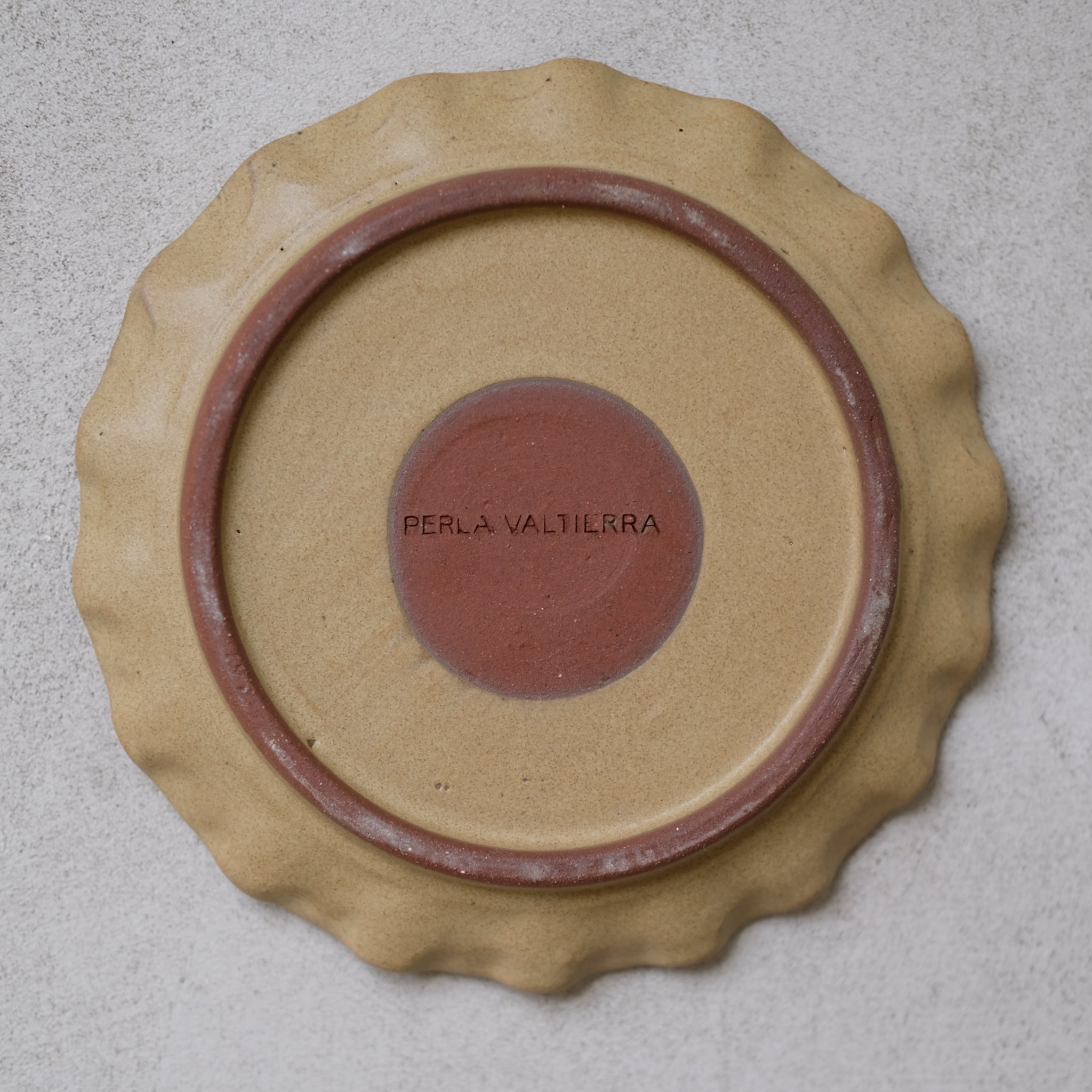 Les assiettes en argile rouge moutarde de Perla Valtierra chez Brutal Ceramics