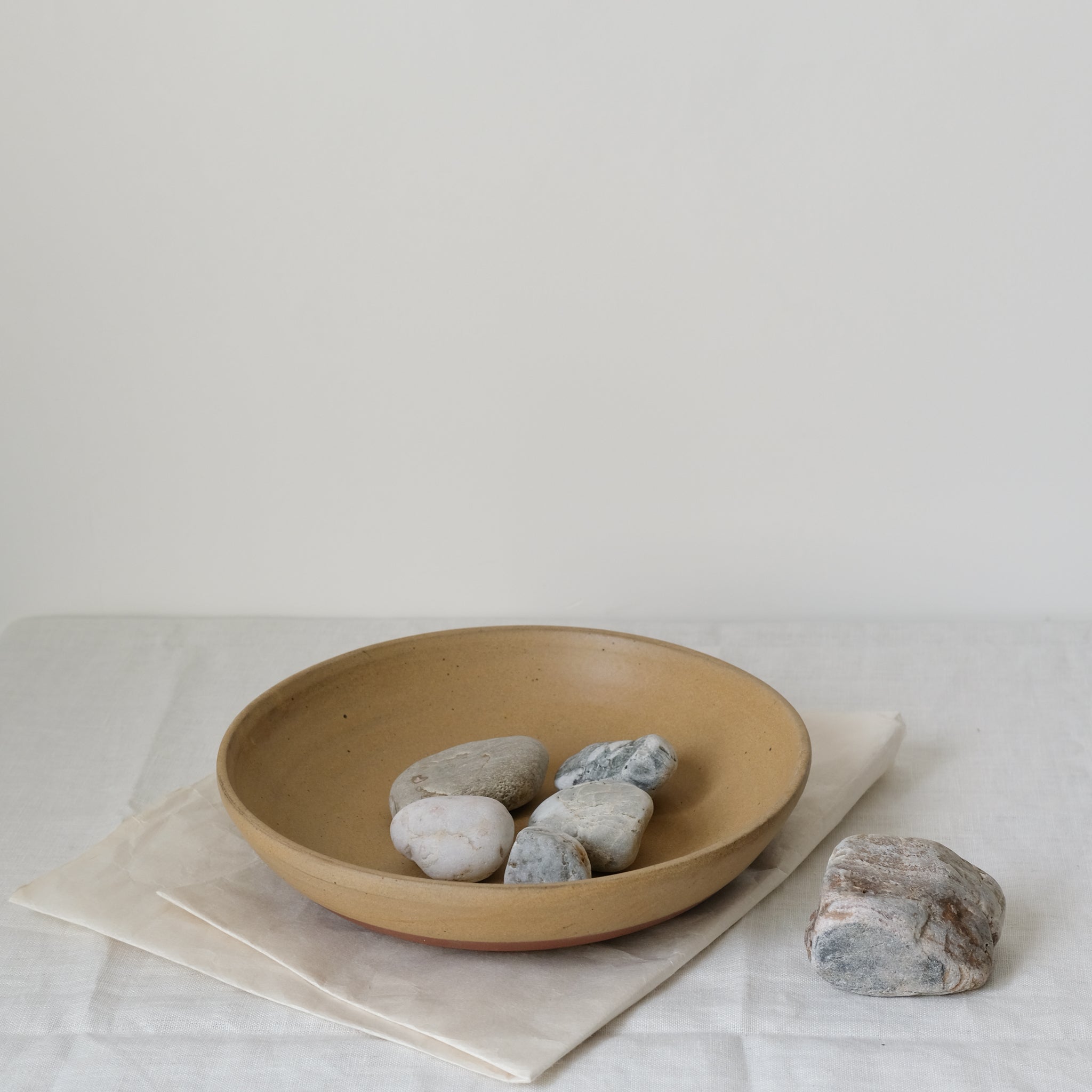 Plat de service en argile moutarde de Perla Valtierra chez Brutal Ceramics