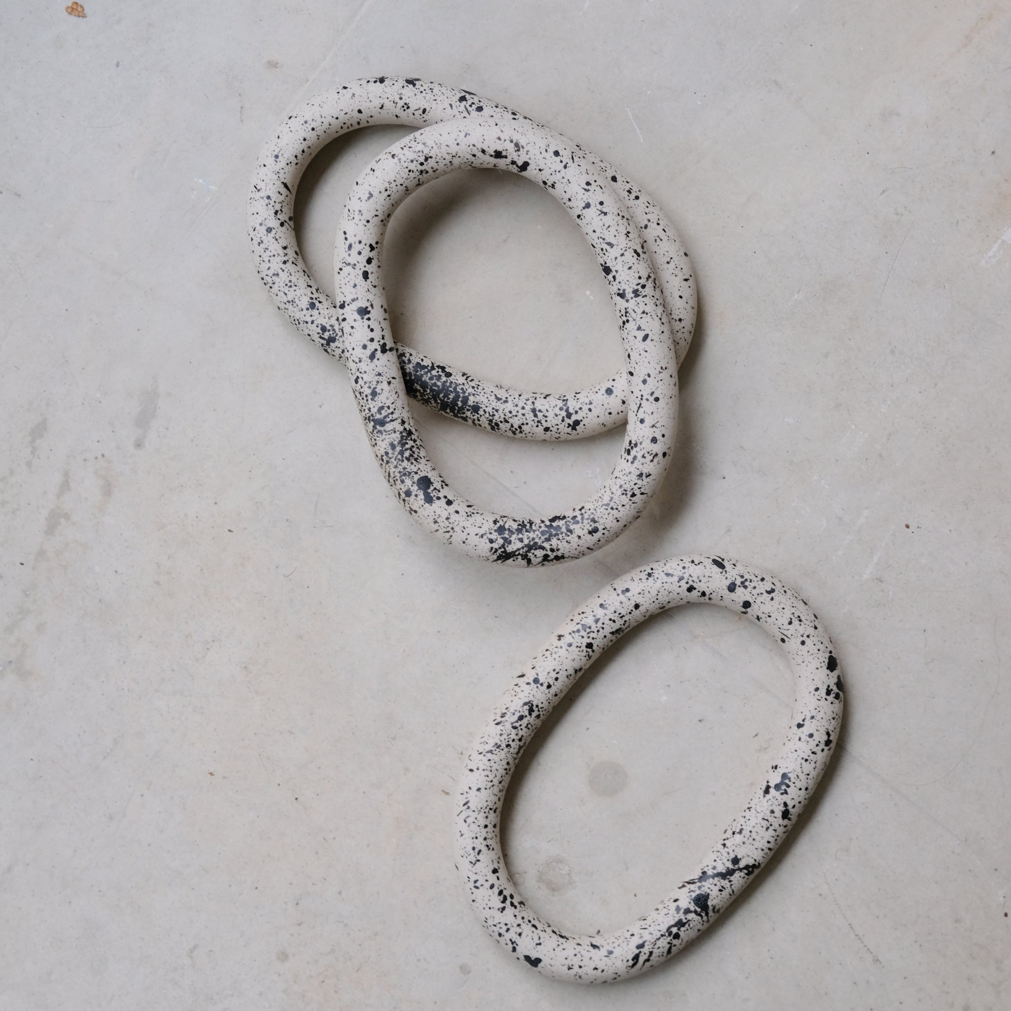 Dessous de plat moucheté noir de Camille Esnée chez Brutal Ceramics