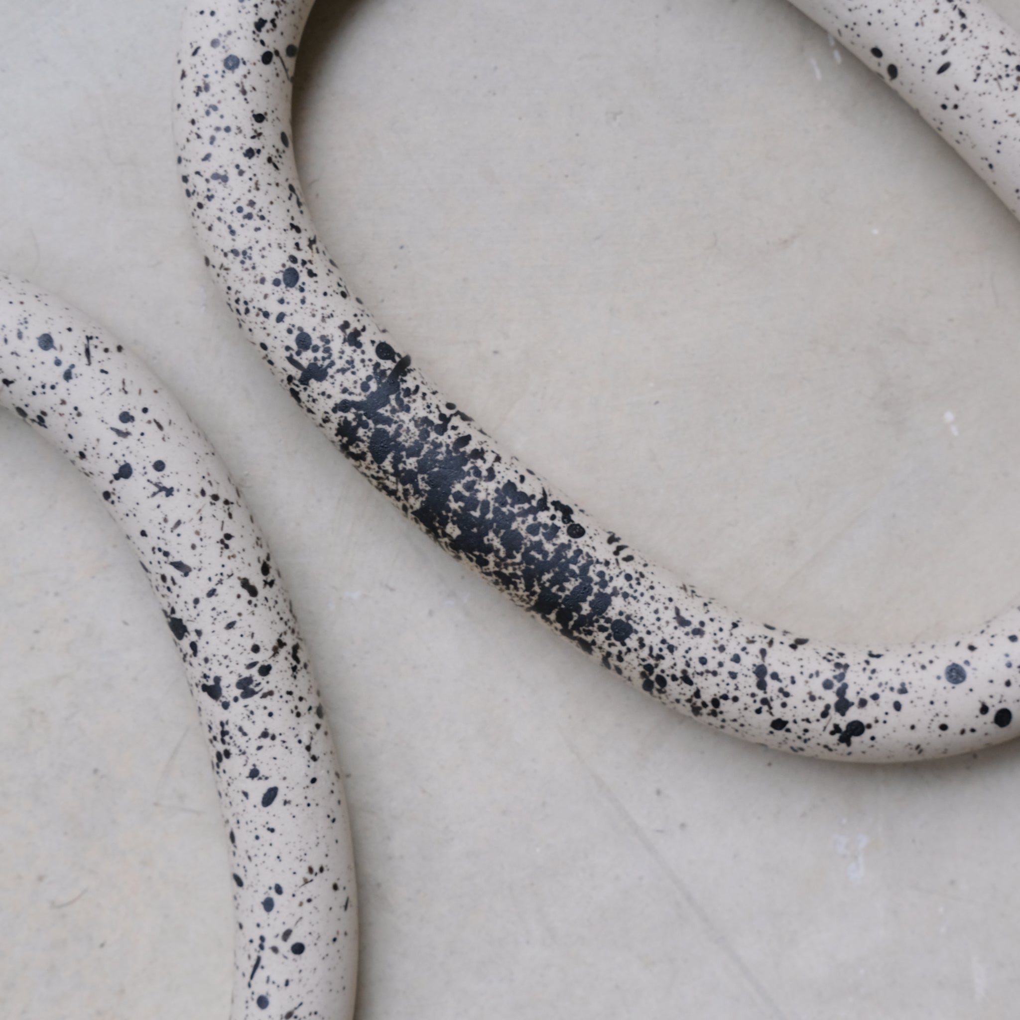 Dessous de plat moucheté noir de Camille Esnée chez Brutal Ceramics