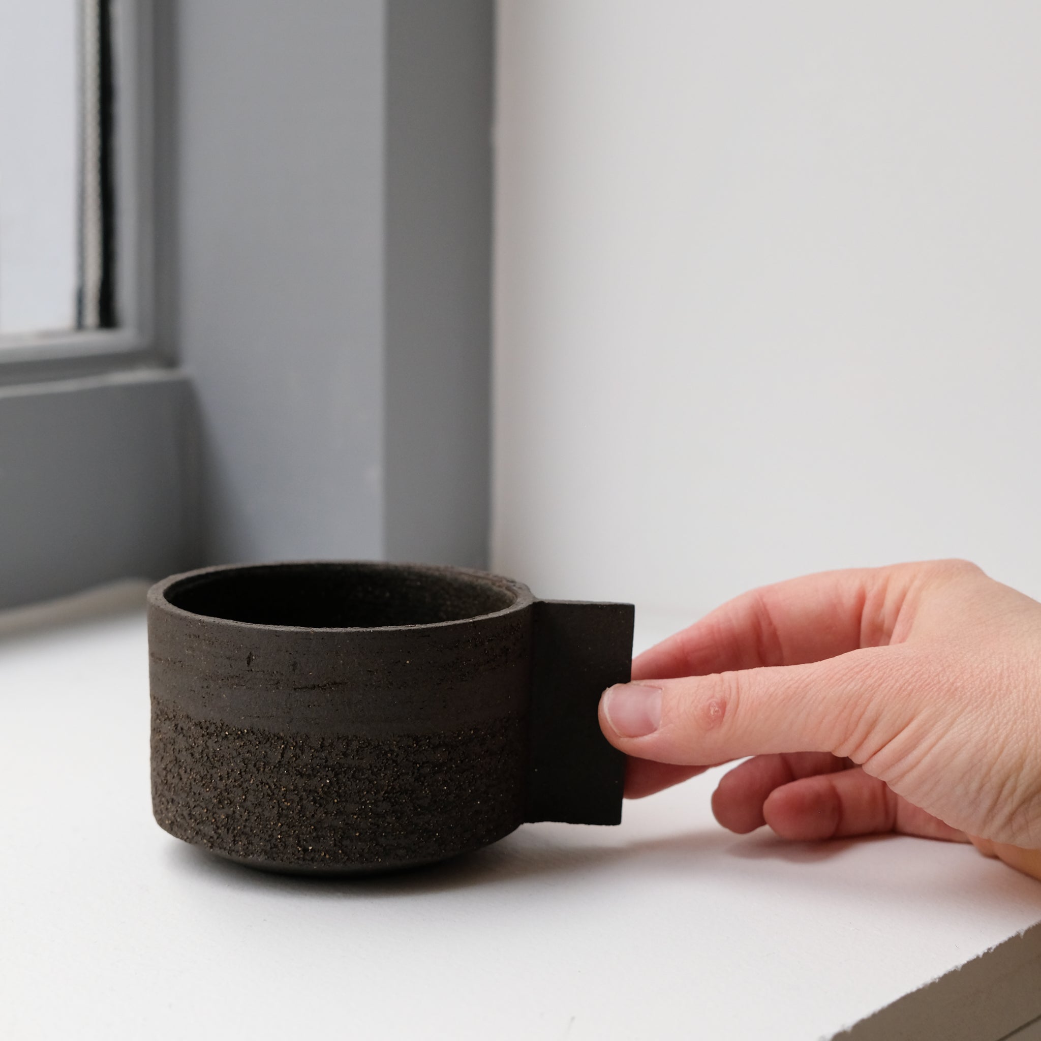 Tasse en grès noir chamotté par Studio Racines chez Brutal