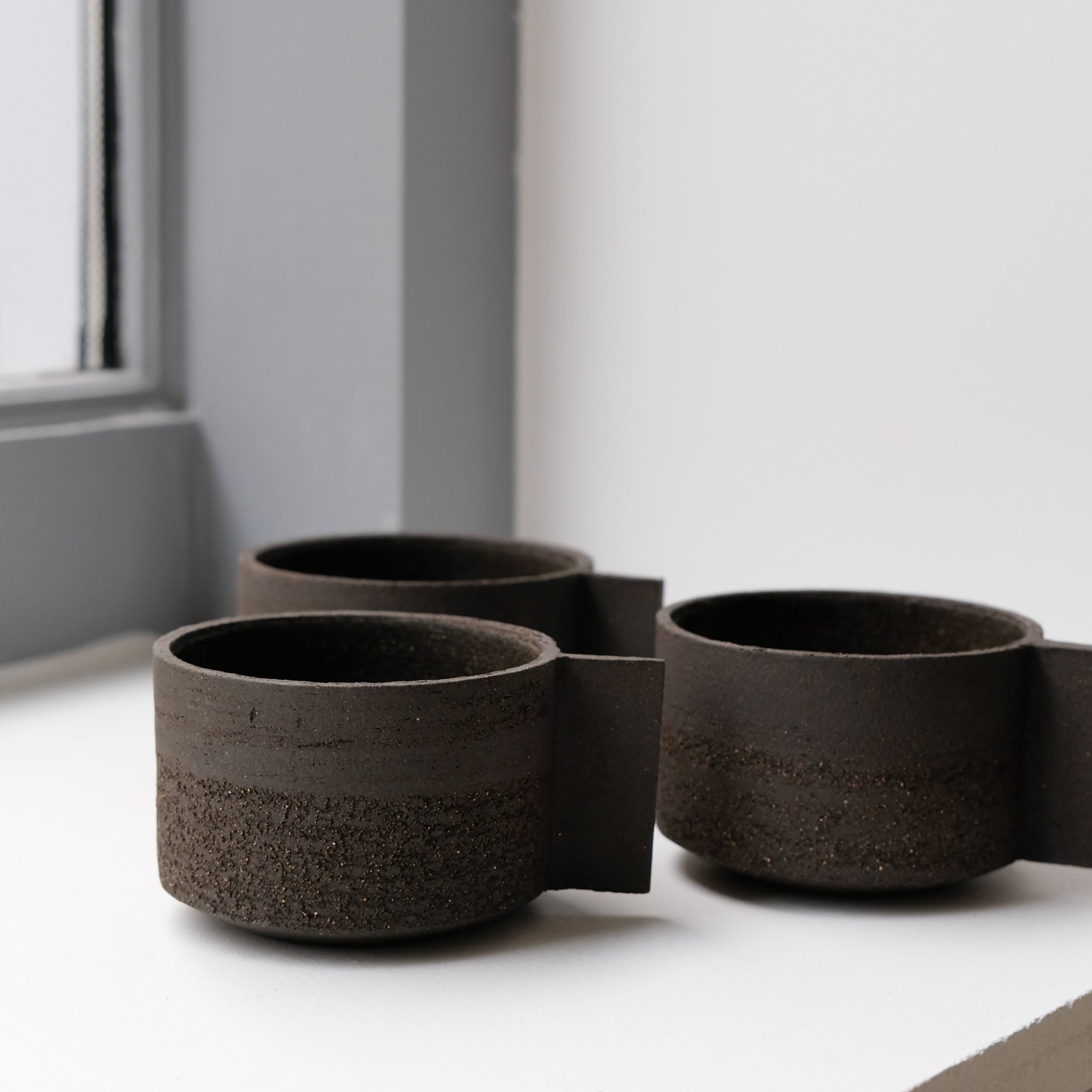 Tasse en grès noir chamotté par Studio Racines chez Brutal