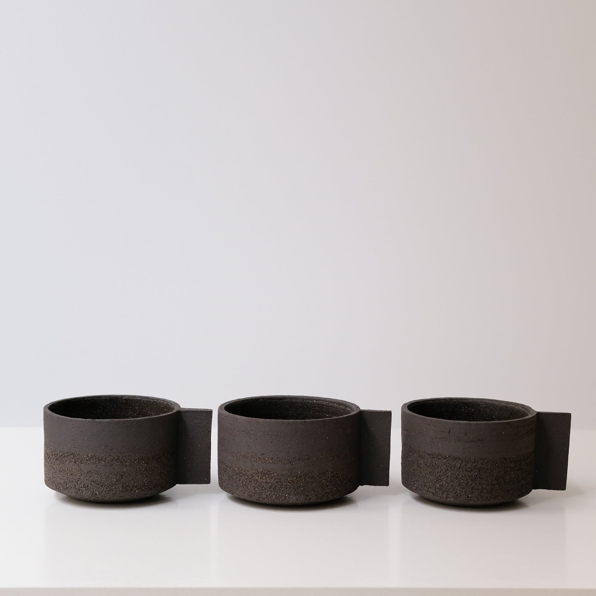 Tasse en grès noir chamotté par Studio Racines chez Brutal