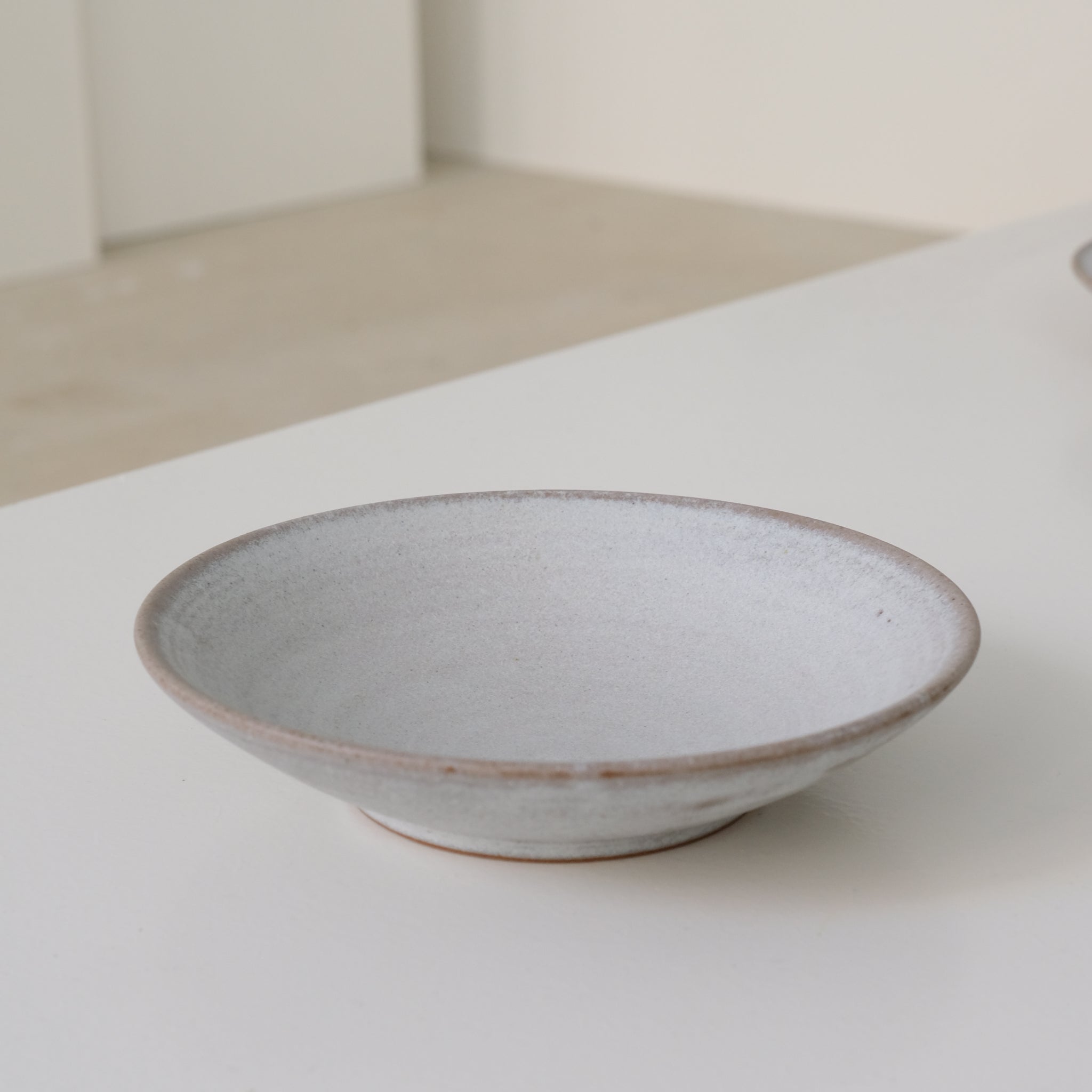 Assiette creuse en grès blanc gris de dunp chez Brutal Ceramics