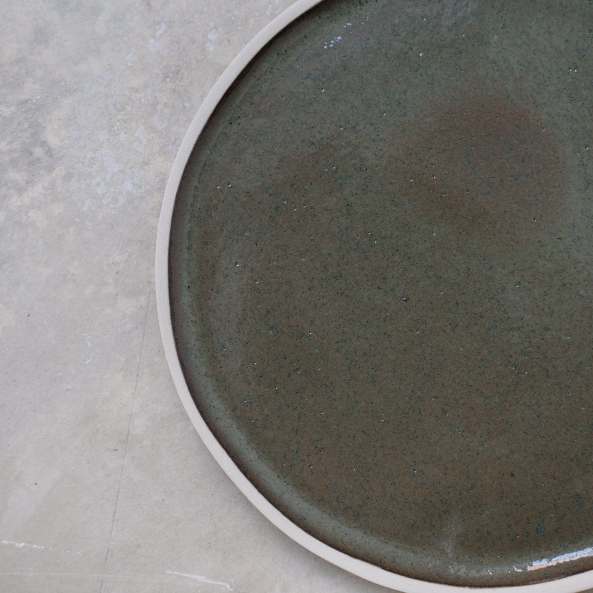 Assiette en grès vert sous bois de Laurette Broll chez Brutal Ceramics