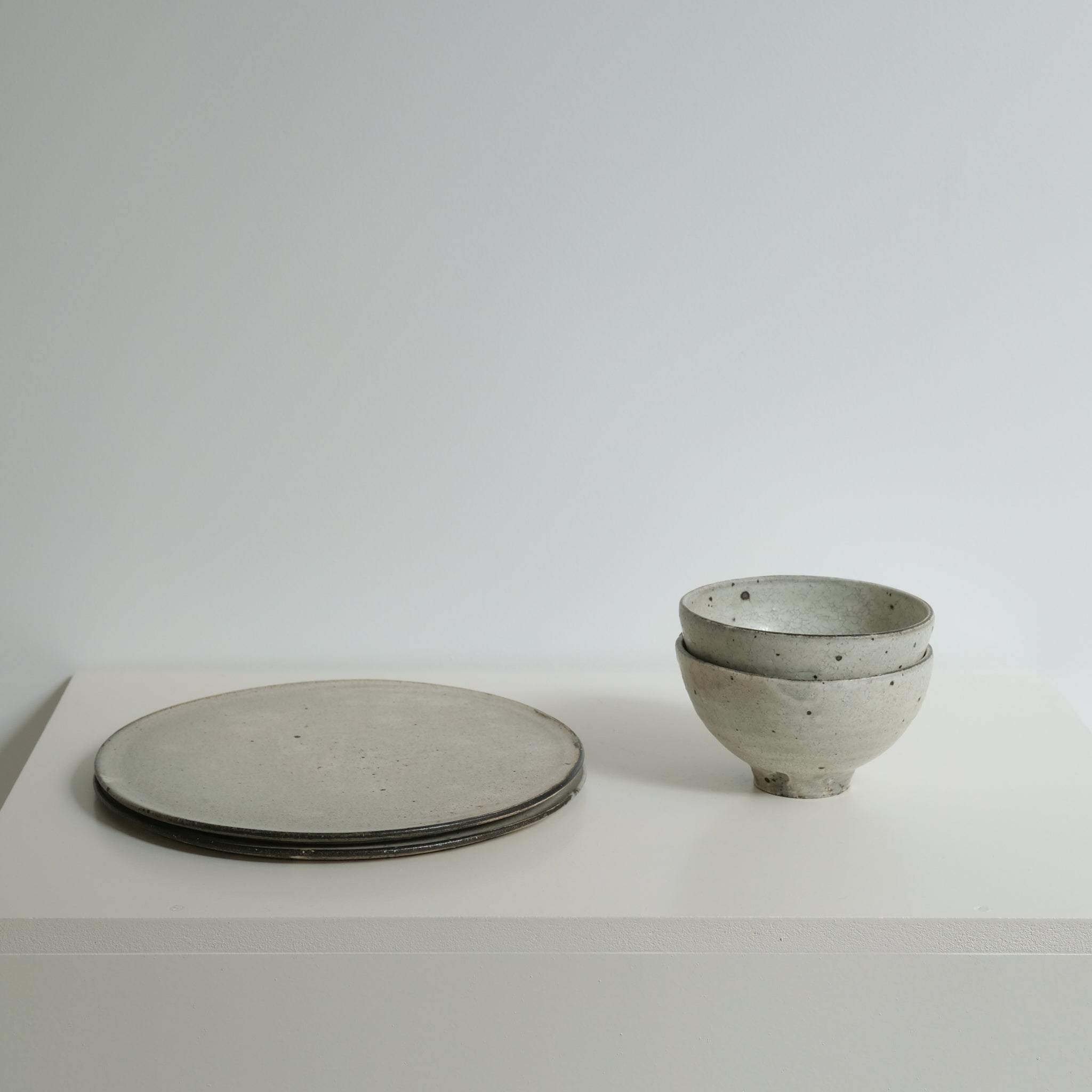 Assiette en grès gris D 26cm - blanc cassé de Ryutaro Yamada chez Brutal Ceramics
