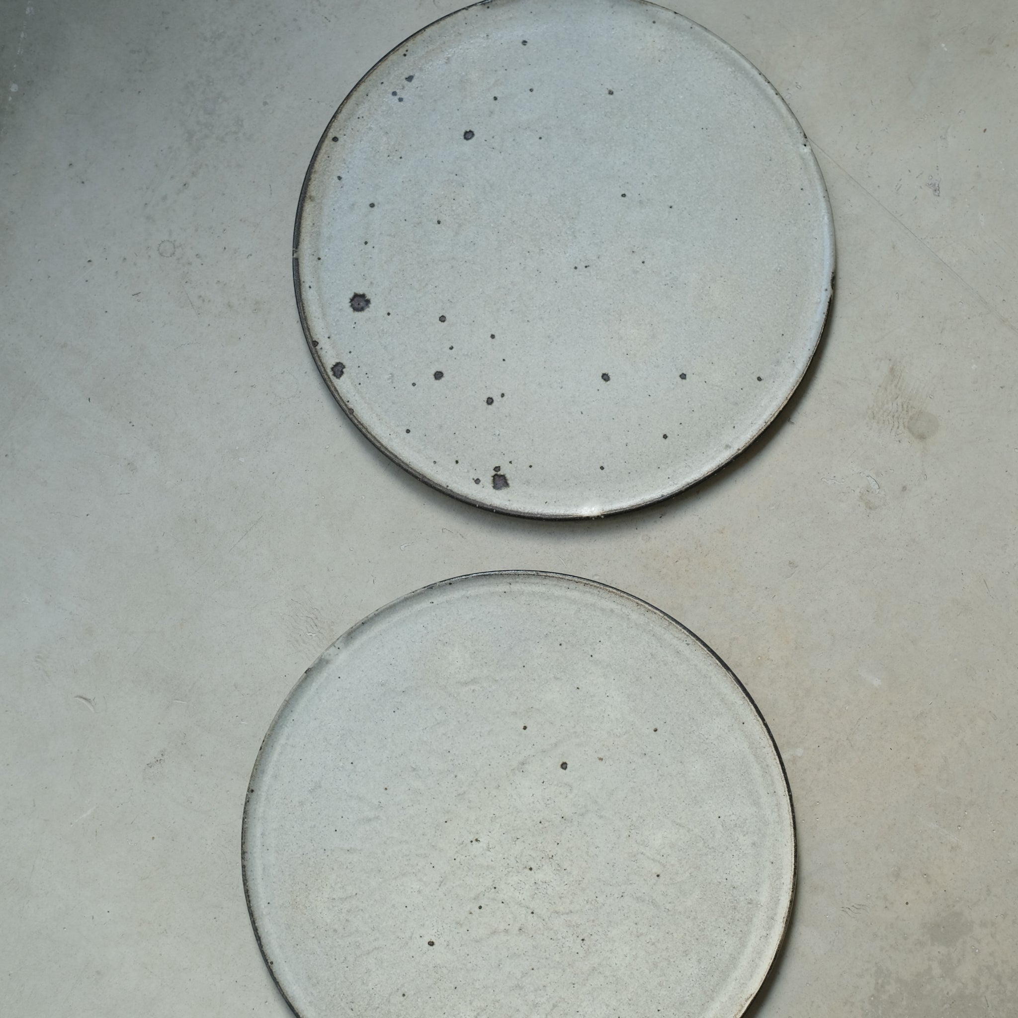 Assiette en grès gris D 26cm - blanc cassé de Ryutaro Yamada chez Brutal Ceramics