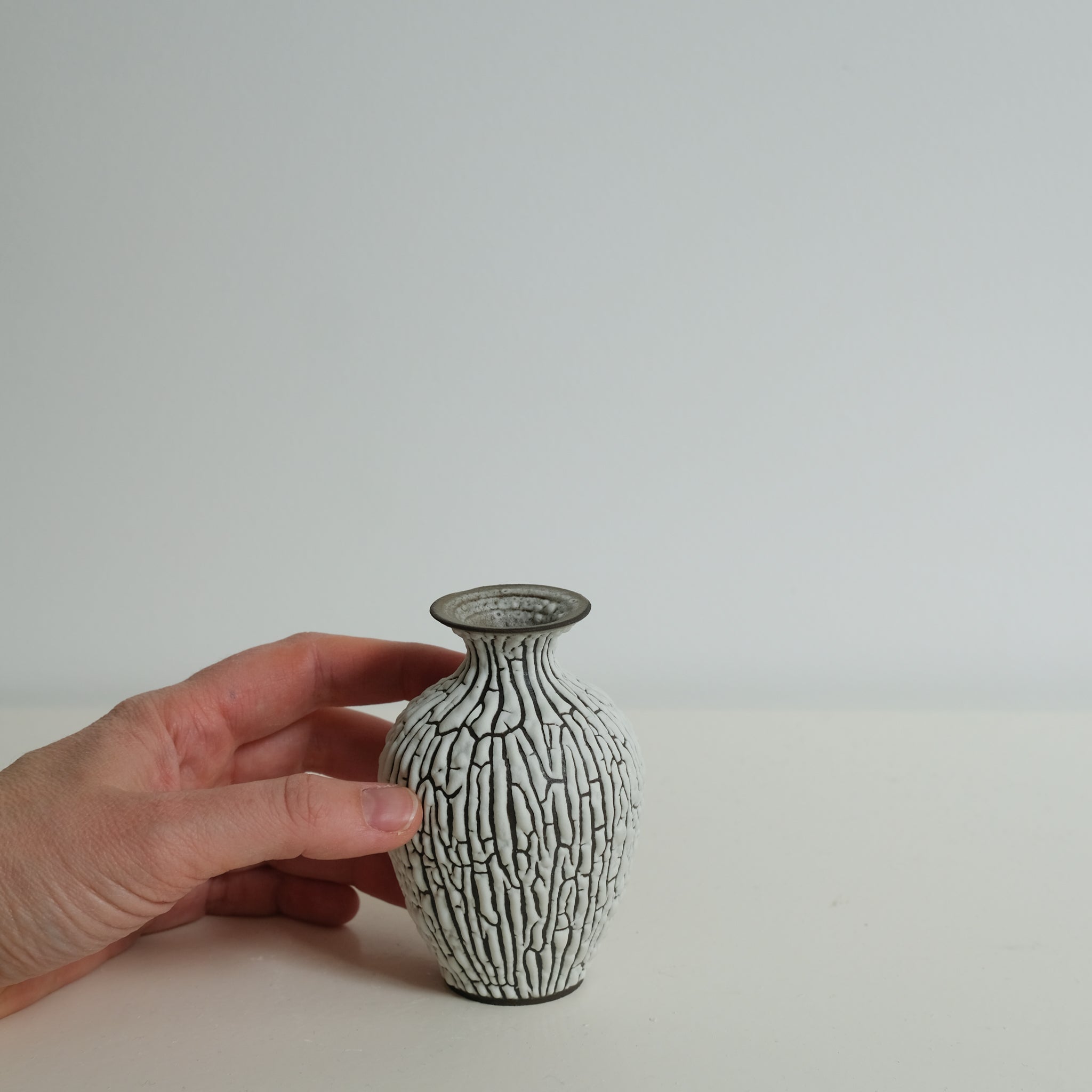 Vase en grès noir H10cm - blanc craquelé de Sharlen Nozawa chez Brutal Ceramics