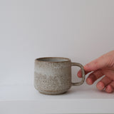 Mug en grès blanc et brun moucheté de Laurence Labbé chez Brutal Ceramics