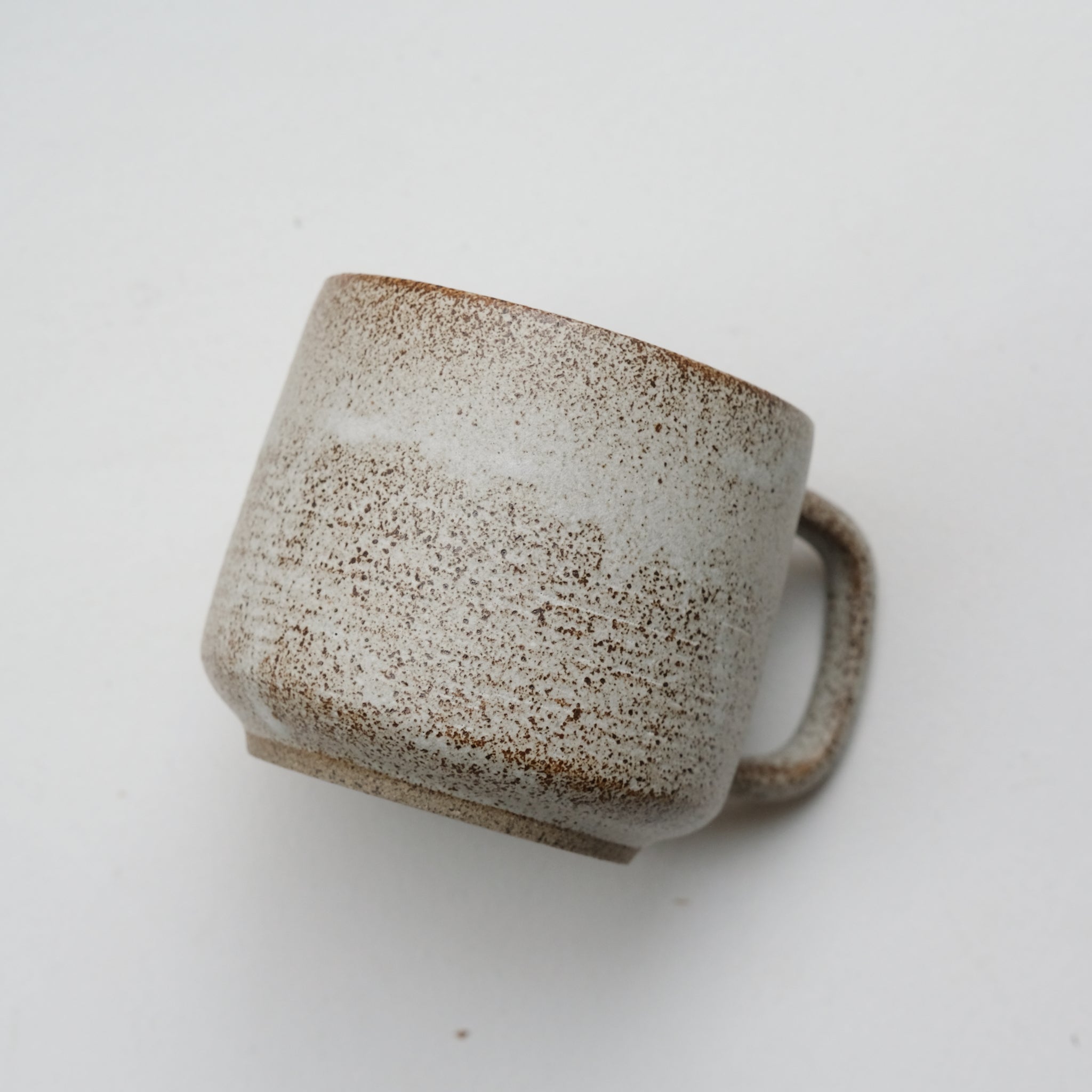Mug en grès blanc et brun moucheté de Laurence Labbé chez Brutal Ceramics