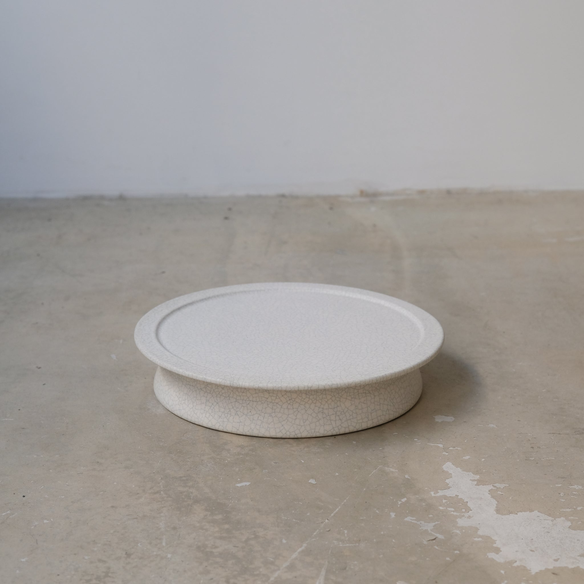 Plateau sur pied - blanc craquelé de Mushimegane books. chez Brutal Ceramics