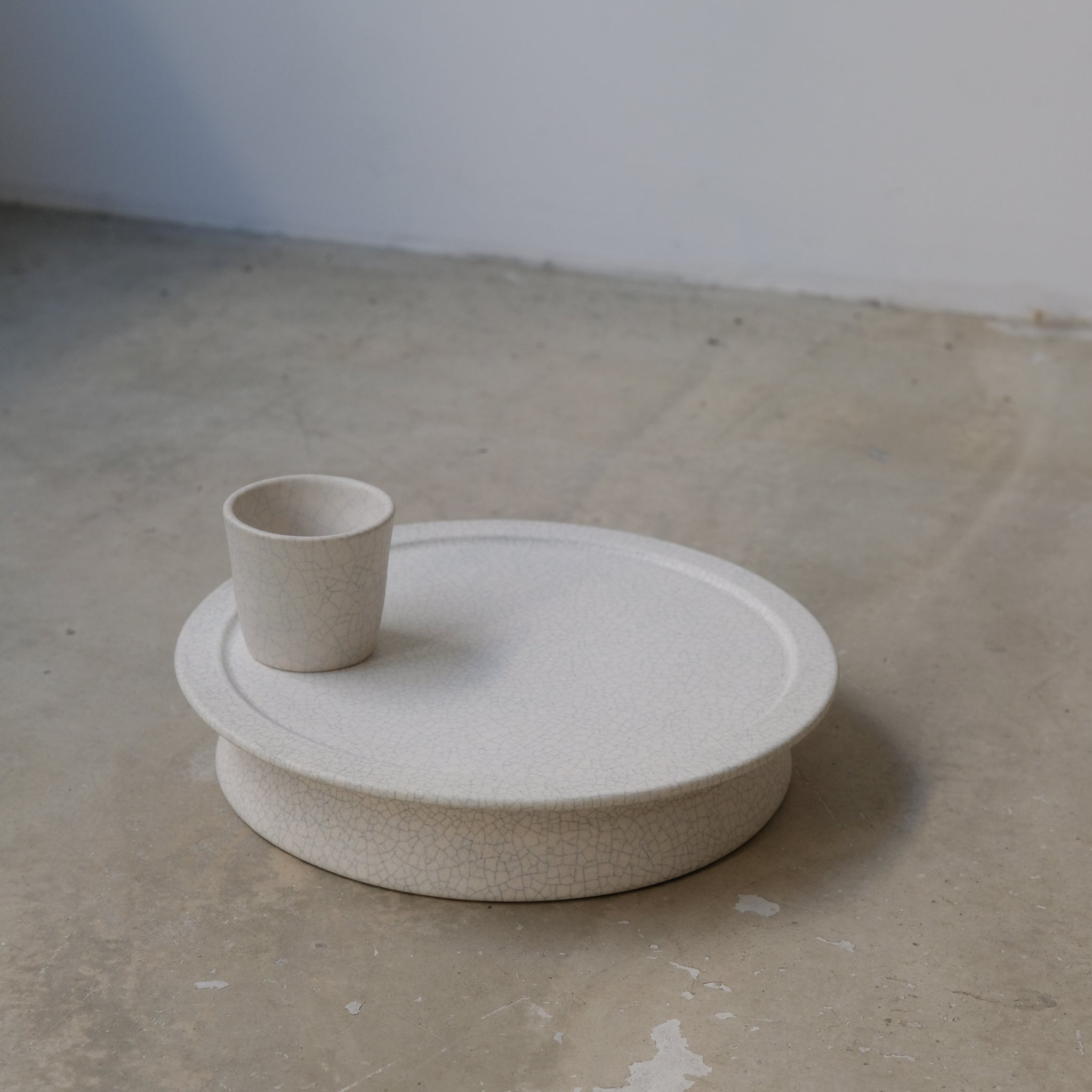 Plateau sur pied - blanc craquelé de Mushimegane books. chez Brutal Ceramics