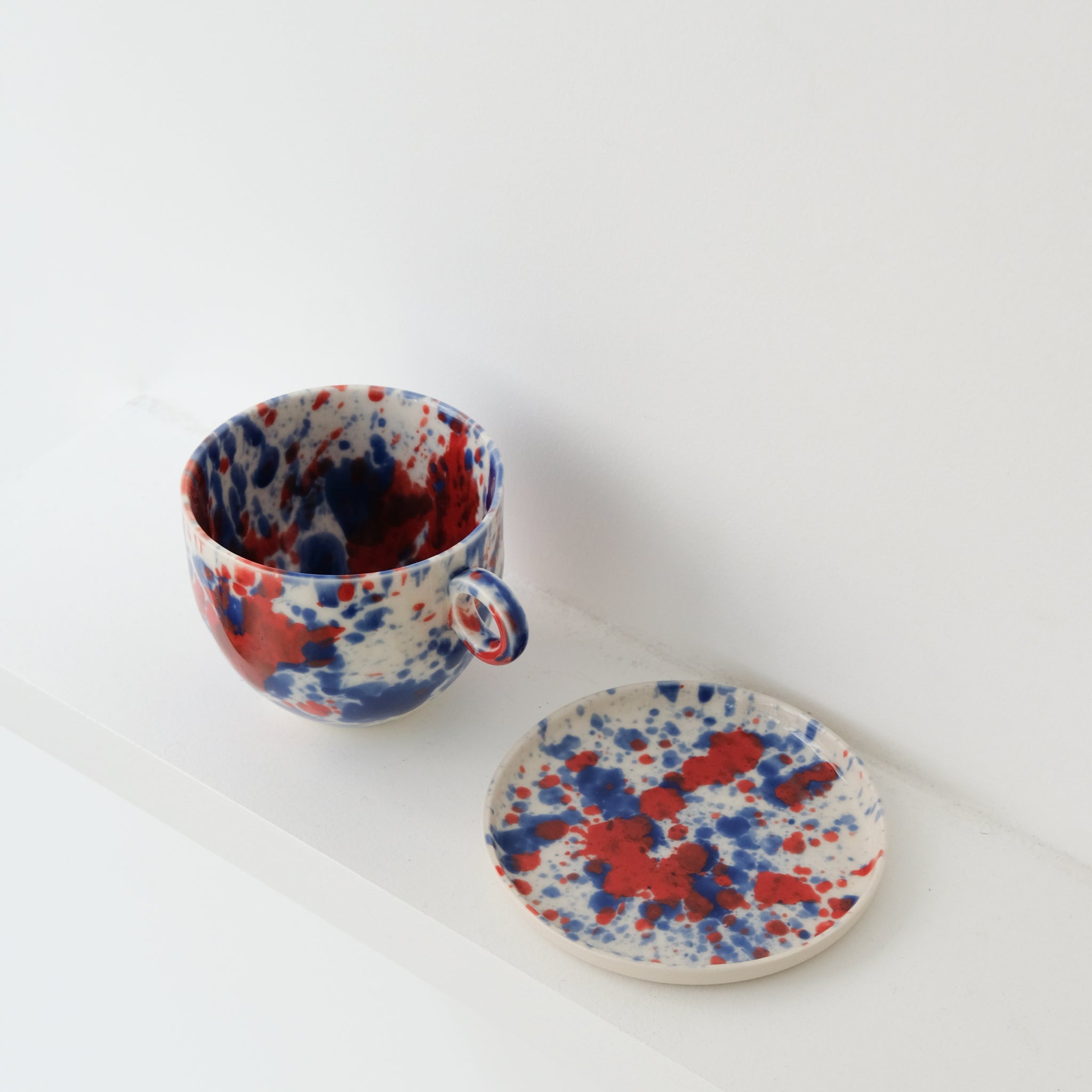 Assiette en porcelaine D11,5cm bleu et rouge d'Anna Jones chez Brutal Ceramics