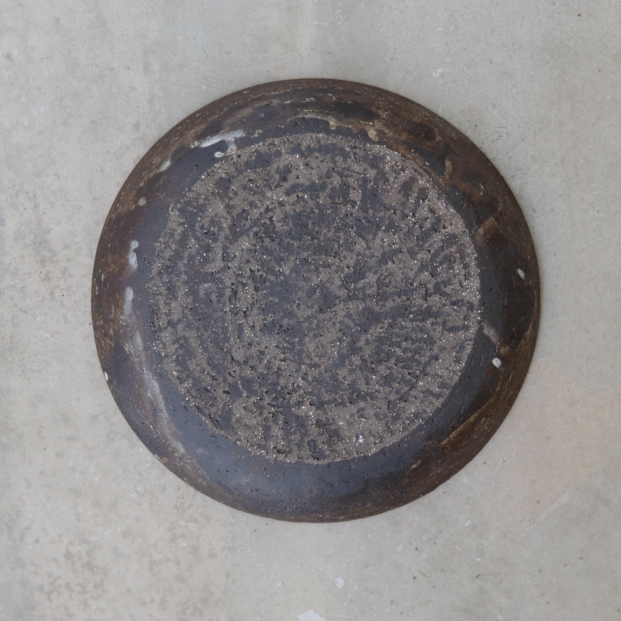 Assiette grès noir D23cm de Michael Buckley chez Brutal Ceramics