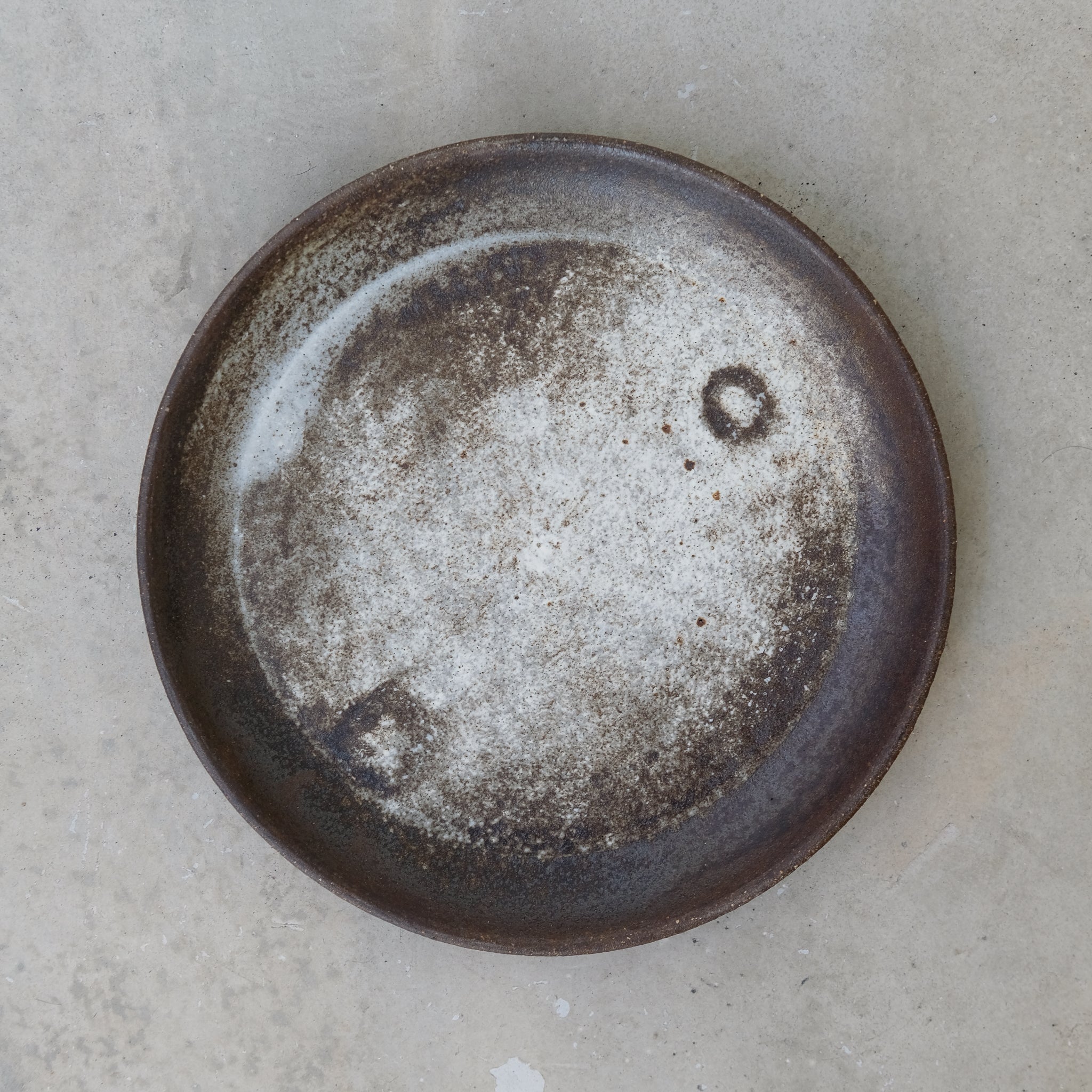 Assiette grès noir D23cm de Michael Buckley chez Brutal Ceramics