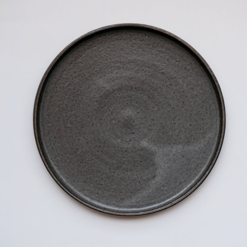Assiette anthracite réalisée par la céramiste Laurence Labbé chez Brutal Ceramics