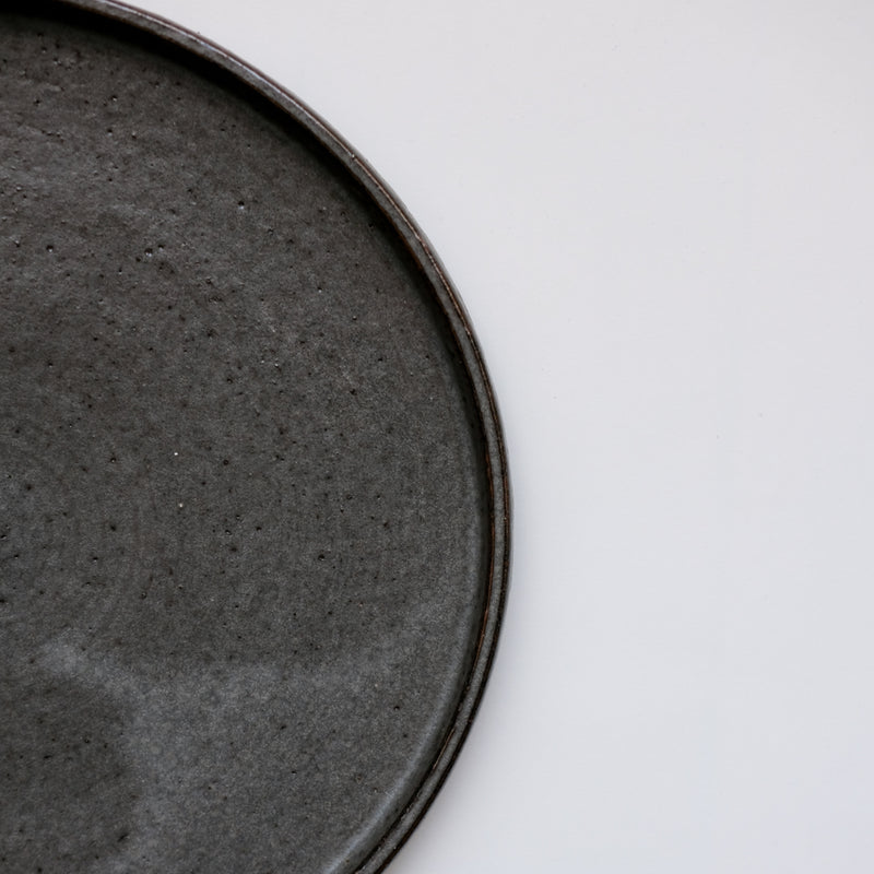 Assiette anthracite réalisée par la céramiste Laurence Labbé chez Brutal Ceramics