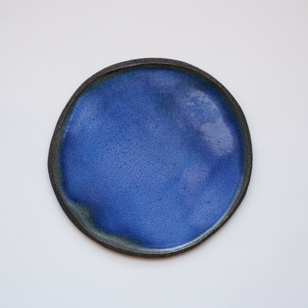 Assiette bleue en grès noir réalisée à la main par Lola Moreau chez Brutal Ceramics