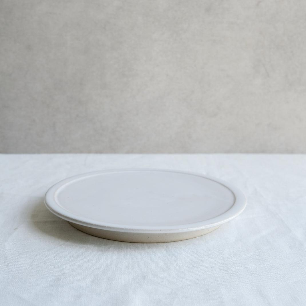 Assiette plate blanche sur pied de Moïo Studio chez Brutal Ceramics