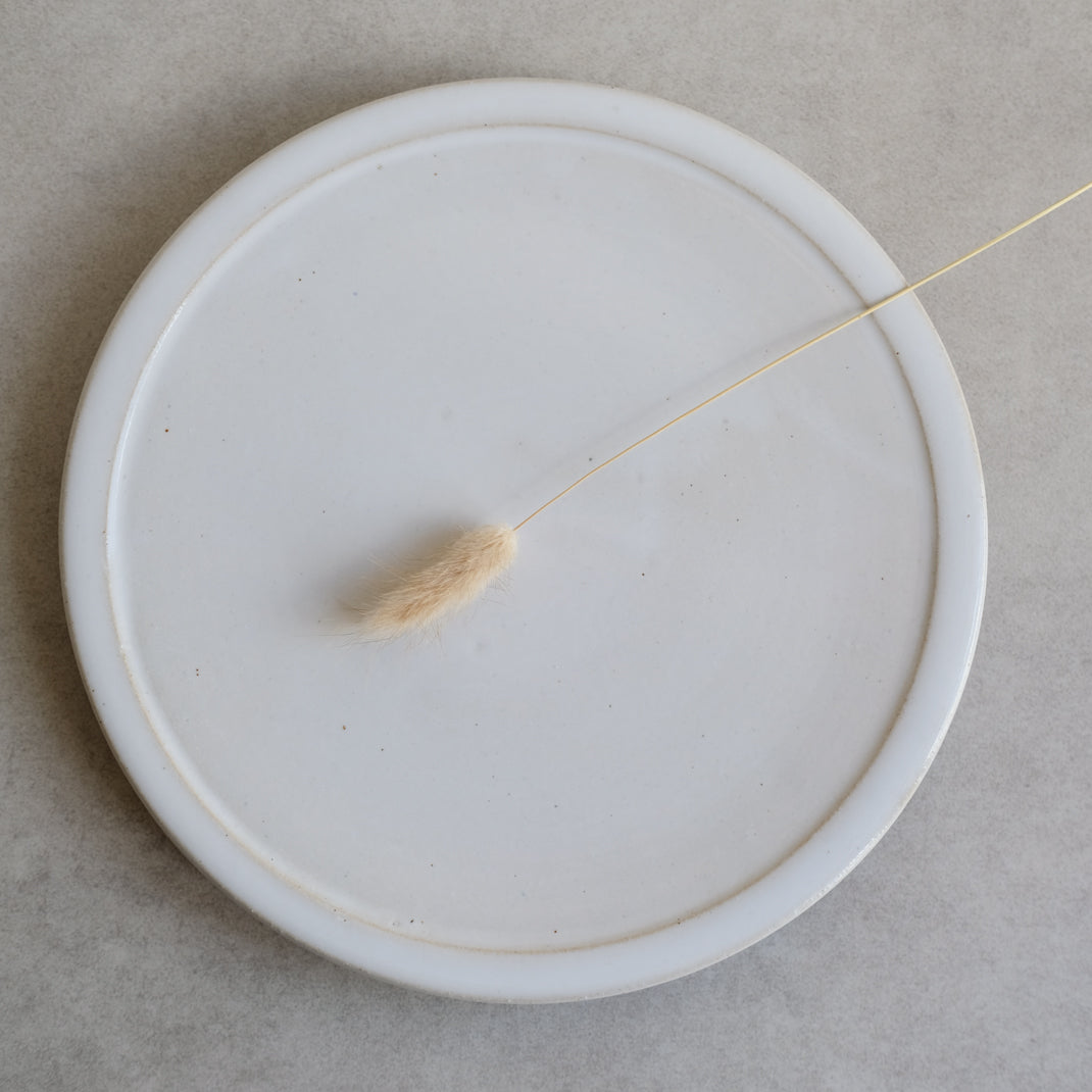 Assiette plate blanche sur pied de Moïo Studio chez Brutal Ceramics
