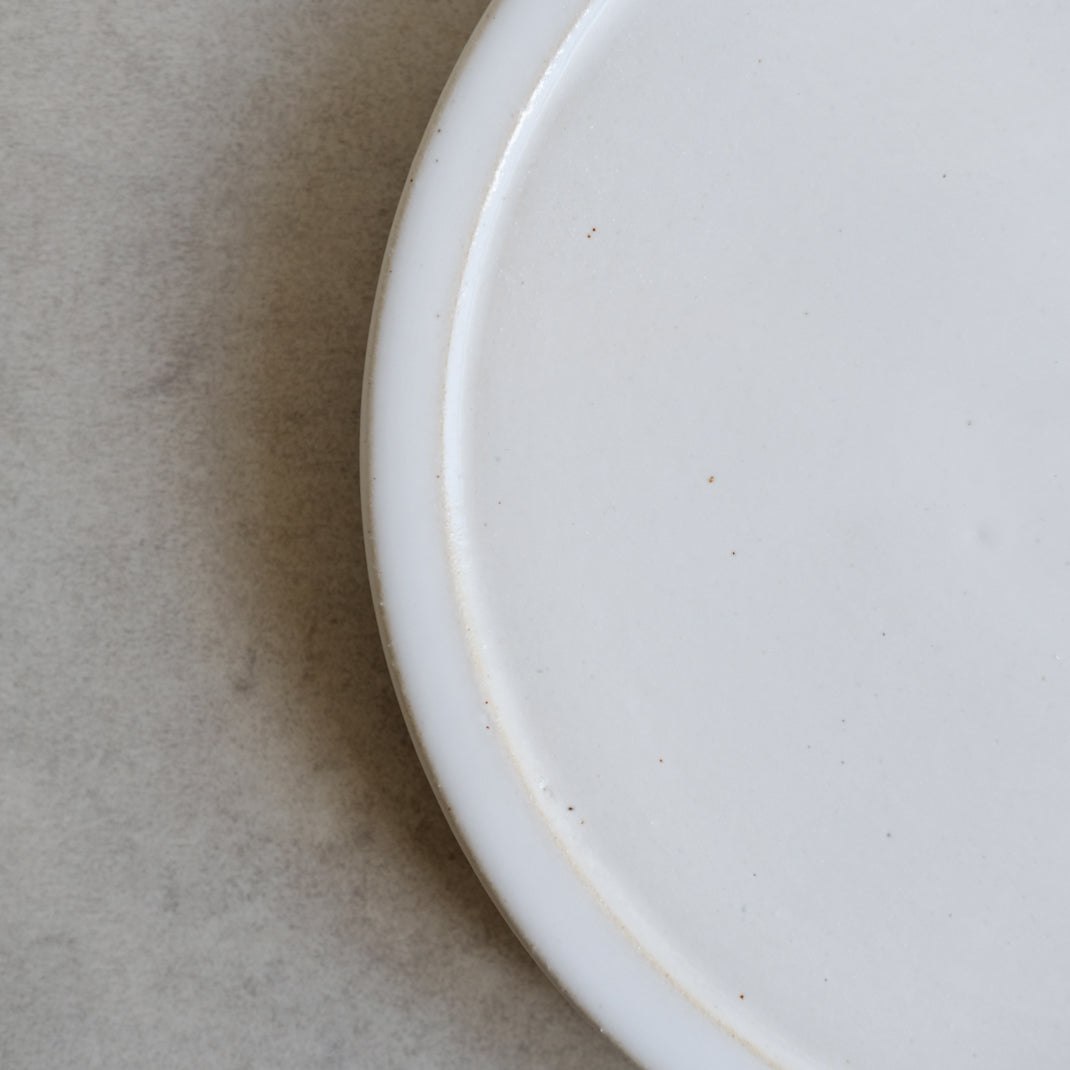 Assiette plate blanche sur pied de Moïo Studio chez Brutal Ceramics