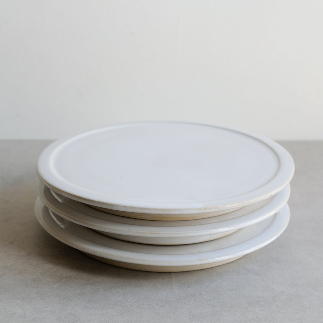 Assiette plate blanche sur pied de Moïo Studio chez Brutal Ceramics