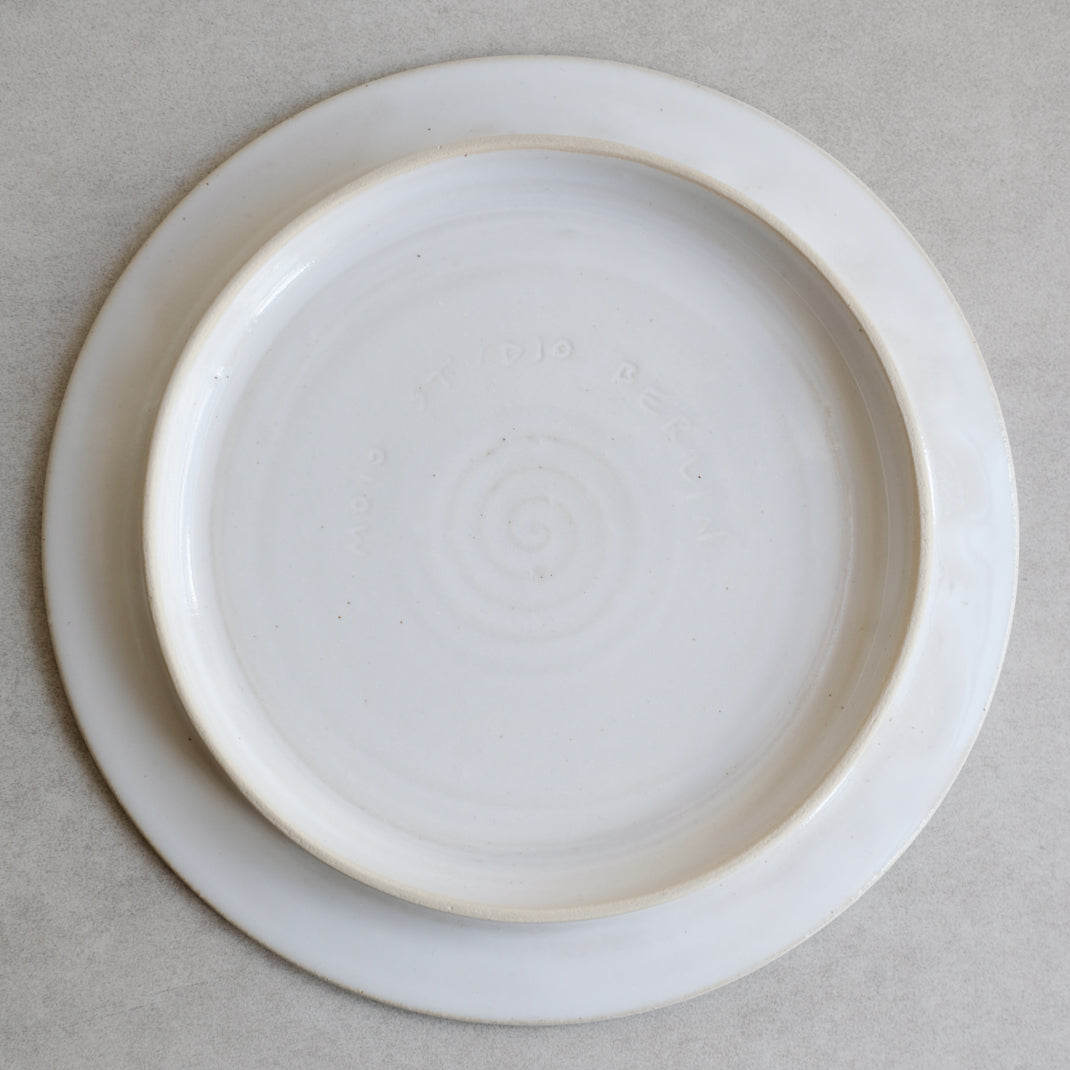 Assiette plate blanche sur pied de Moïo Studio chez Brutal Ceramics