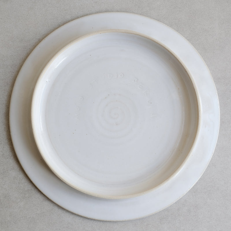 Assiette plate blanche sur pied de Moïo Studio chez Brutal Ceramics