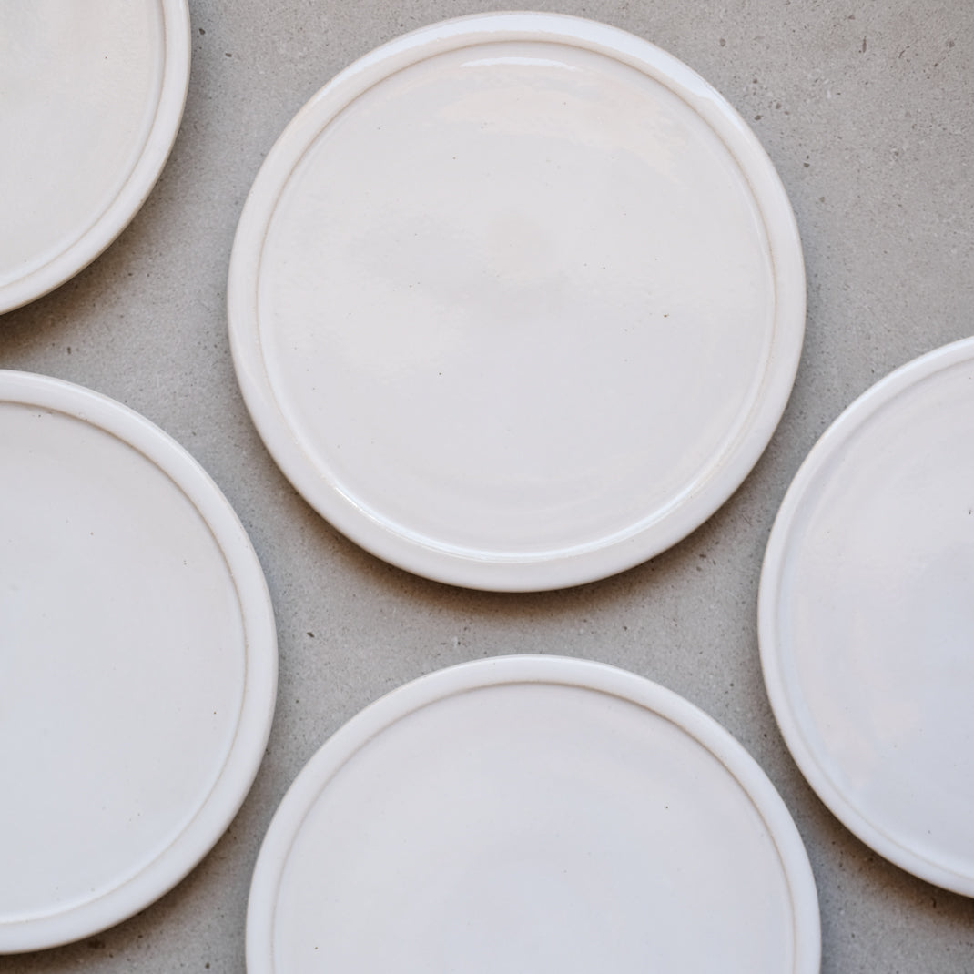 Assiette plate blanche sur pied de Moïo Studio chez Brutal Ceramics